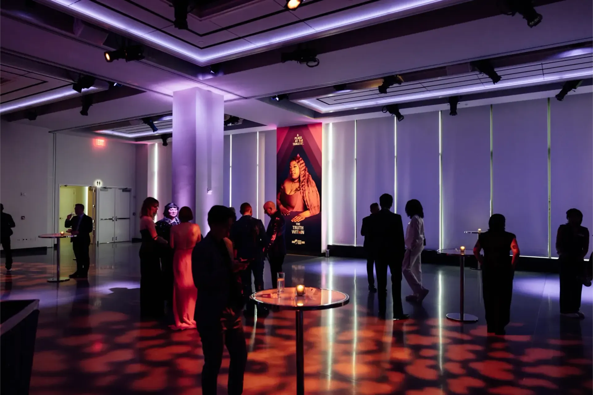 A group of people are standing in a large room.