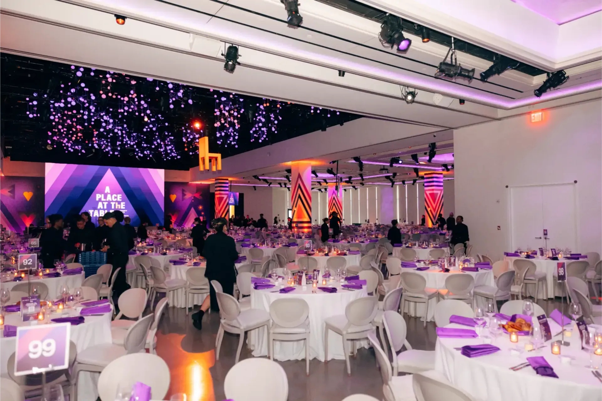 A large room with tables and chairs set up for a party.