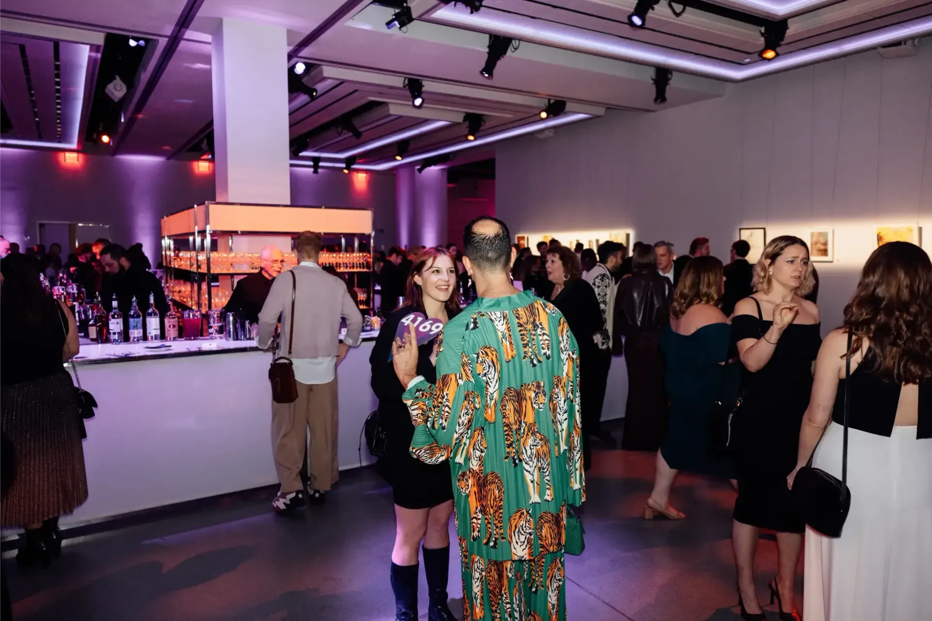 A group of people are standing in a room at a party.
