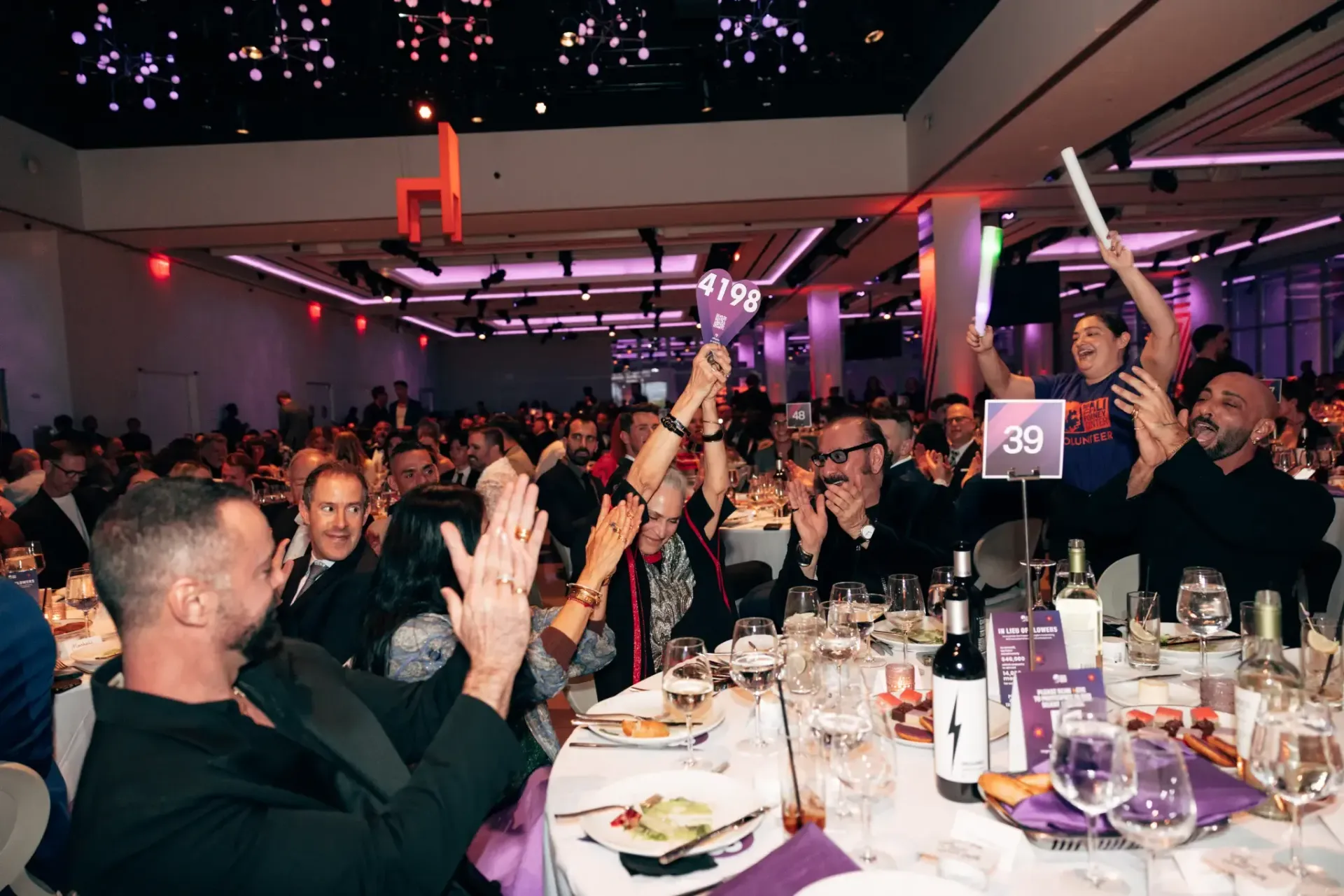 A large group of people are sitting at tables in a large room.