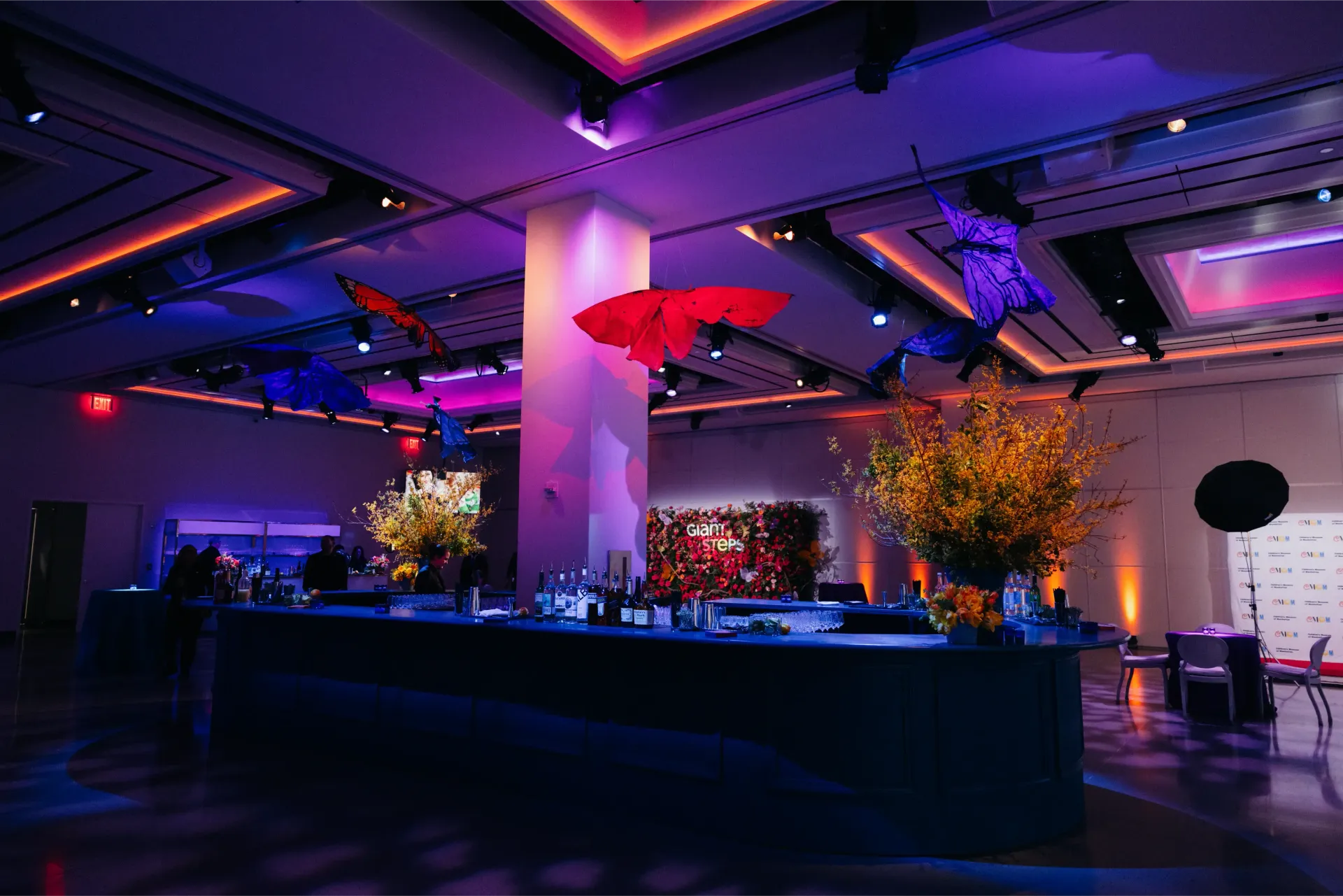 A large room with a bar and umbrellas hanging from the ceiling.