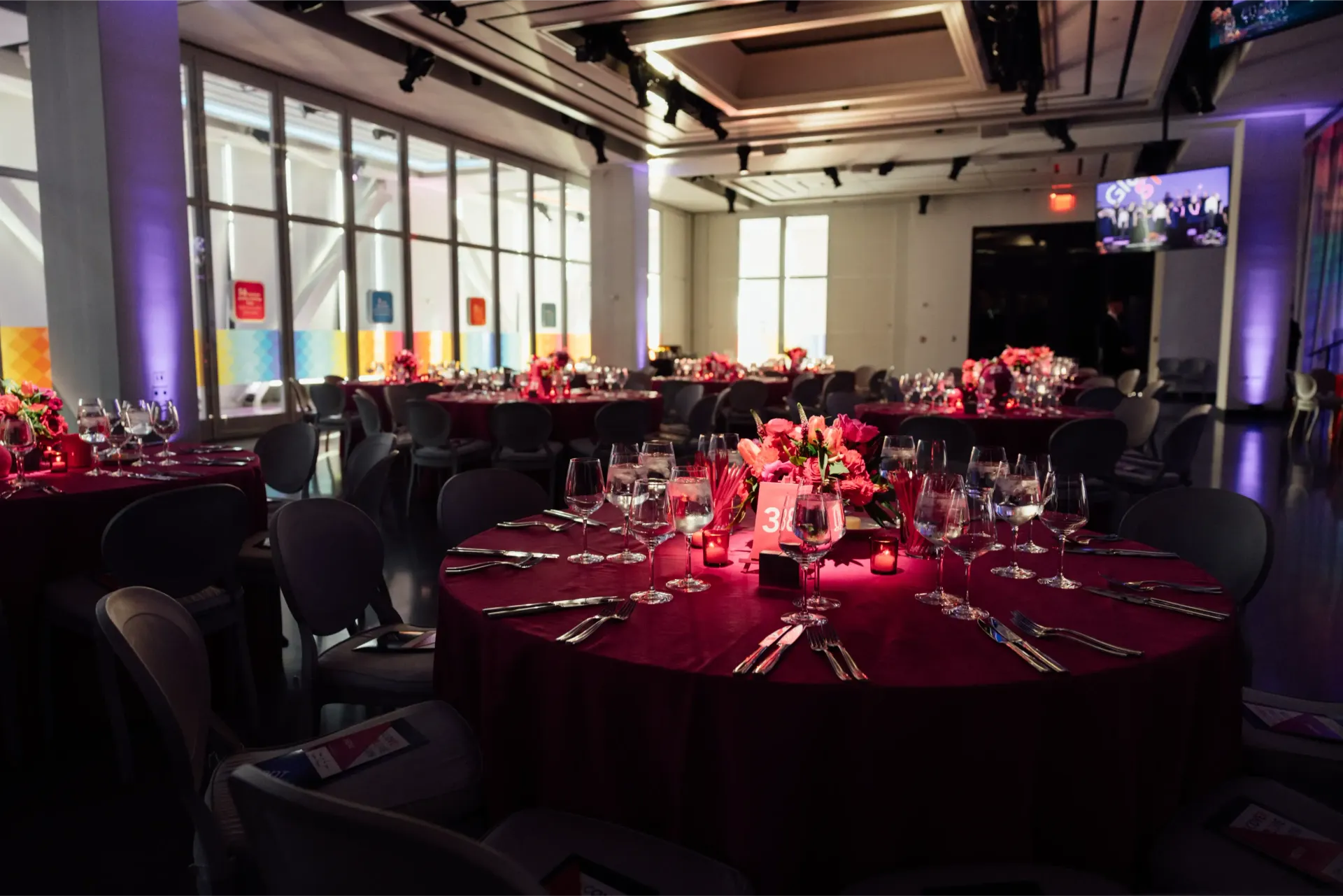 A large room with tables and chairs set up for a party.