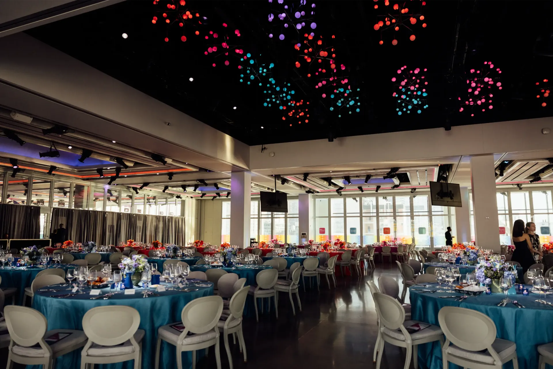 A large room with tables and chairs set up for a party.