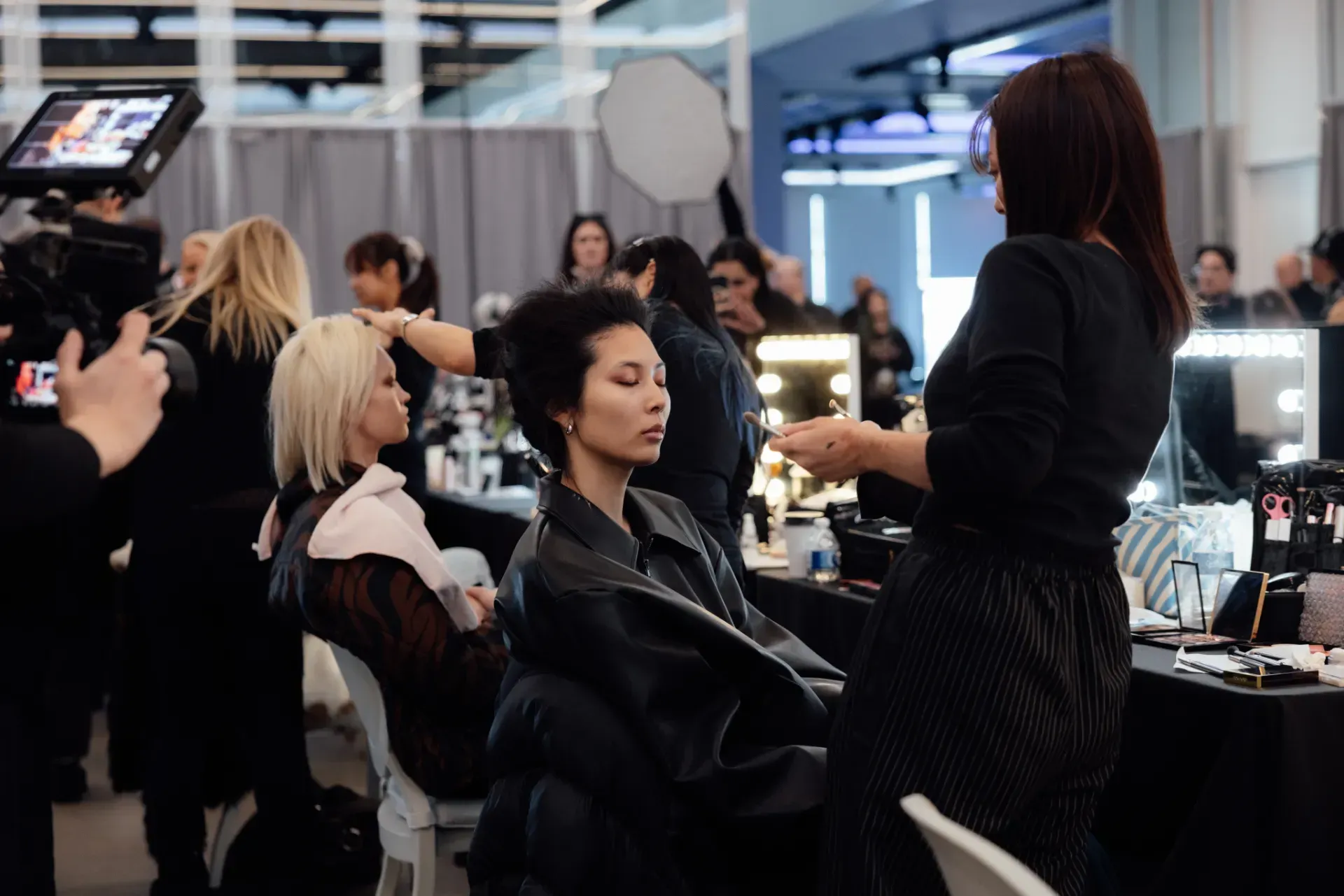 A woman is getting her hair done by a hairdresser in a salon.
