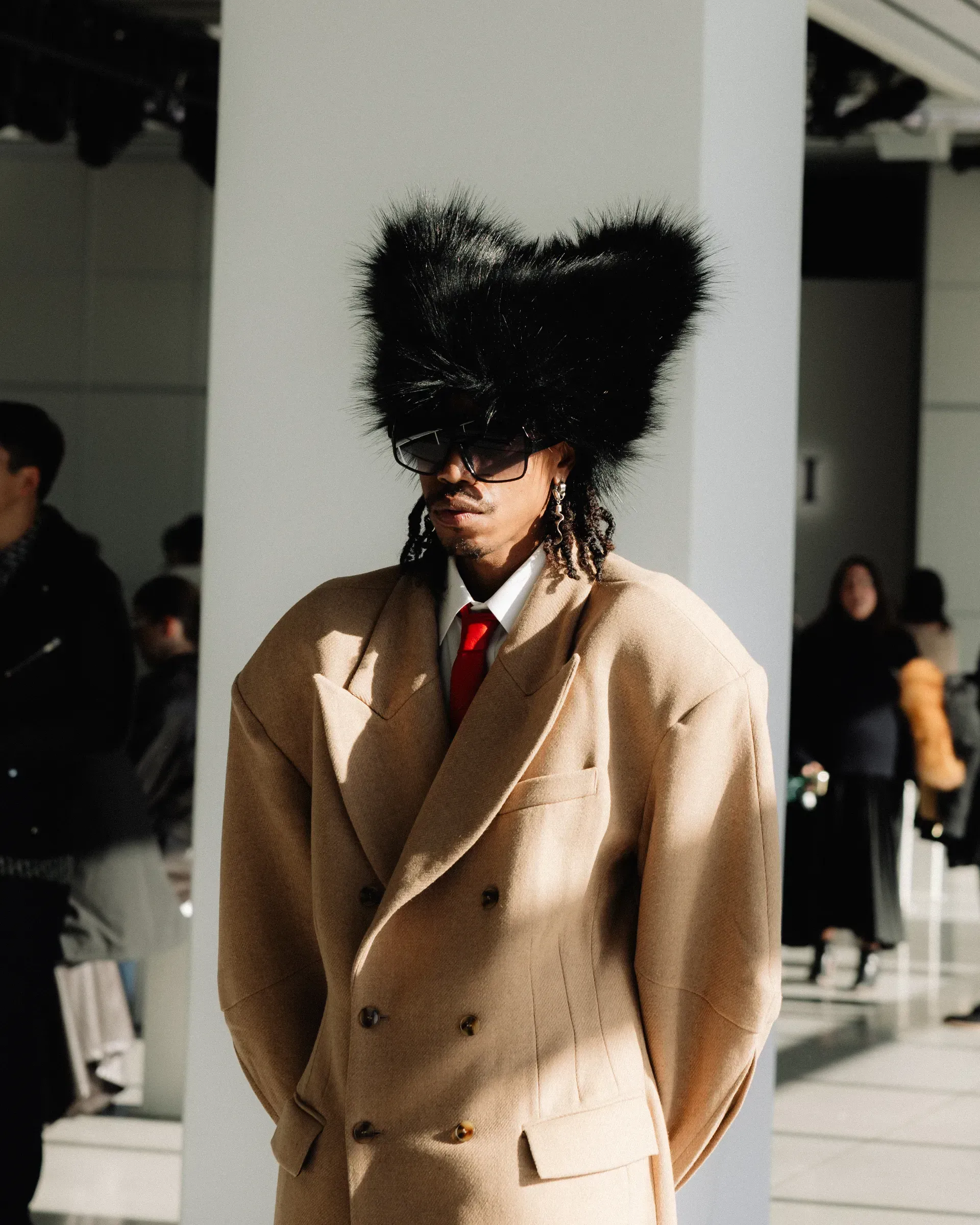 A man wearing a tan suit and a black hat