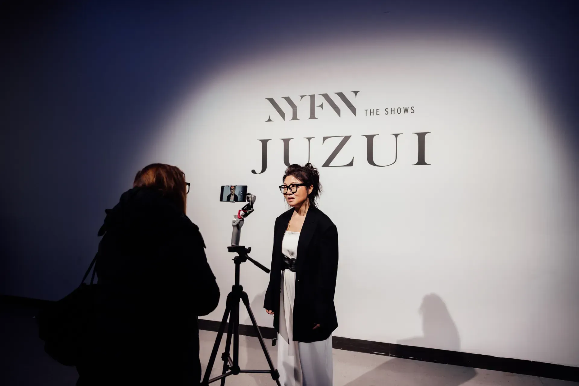 A woman is standing in front of a sign that says juzui