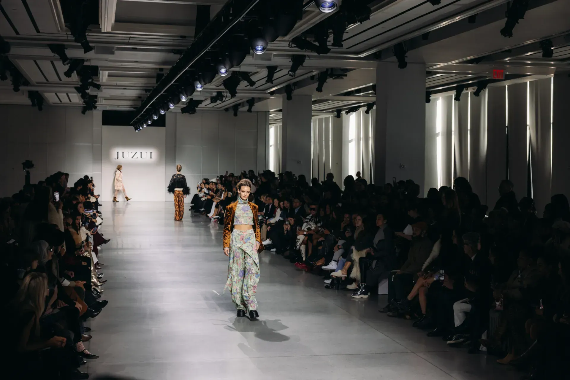 A model is walking down the runway at a fashion show.