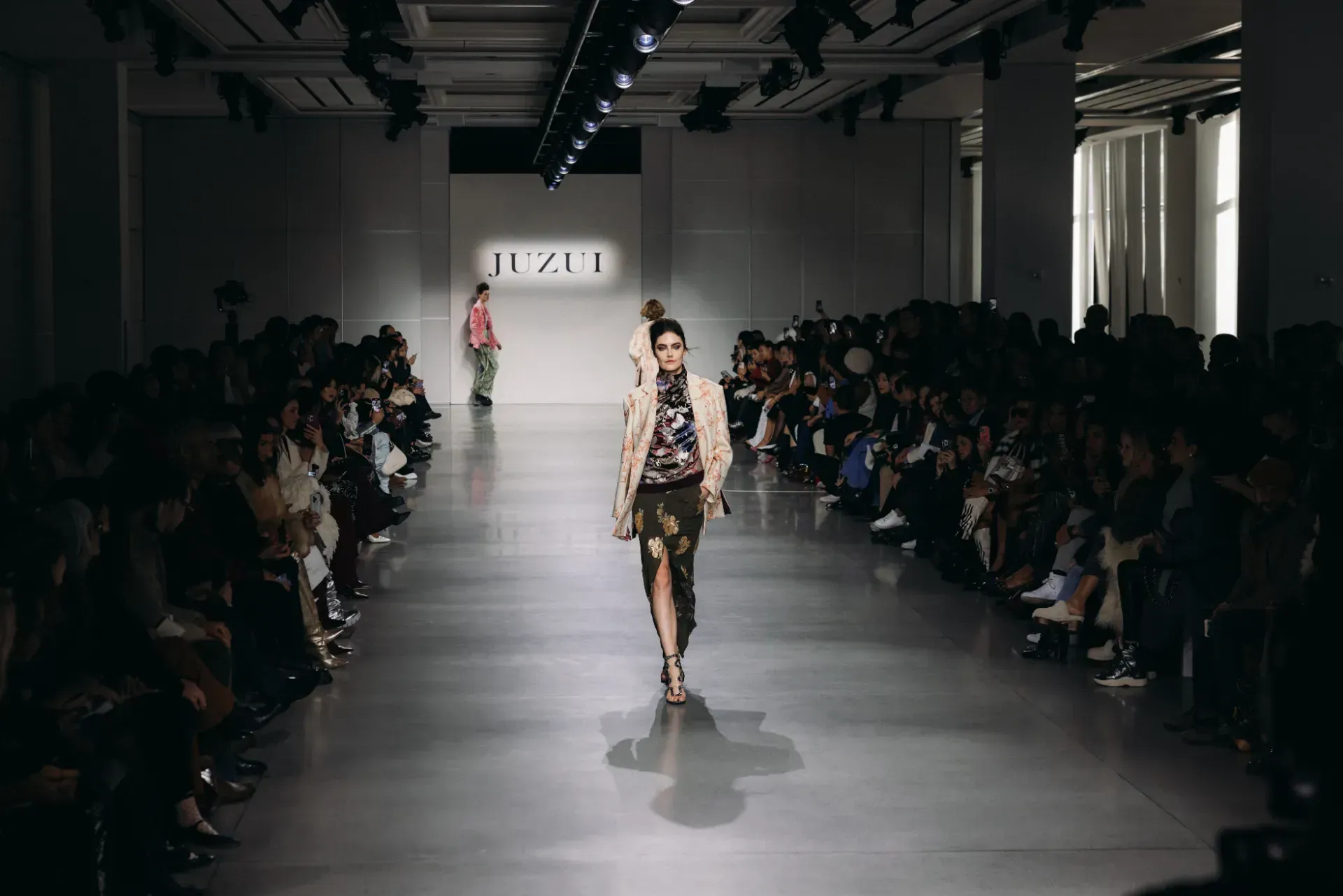 A model is walking down the runway at a fashion show.