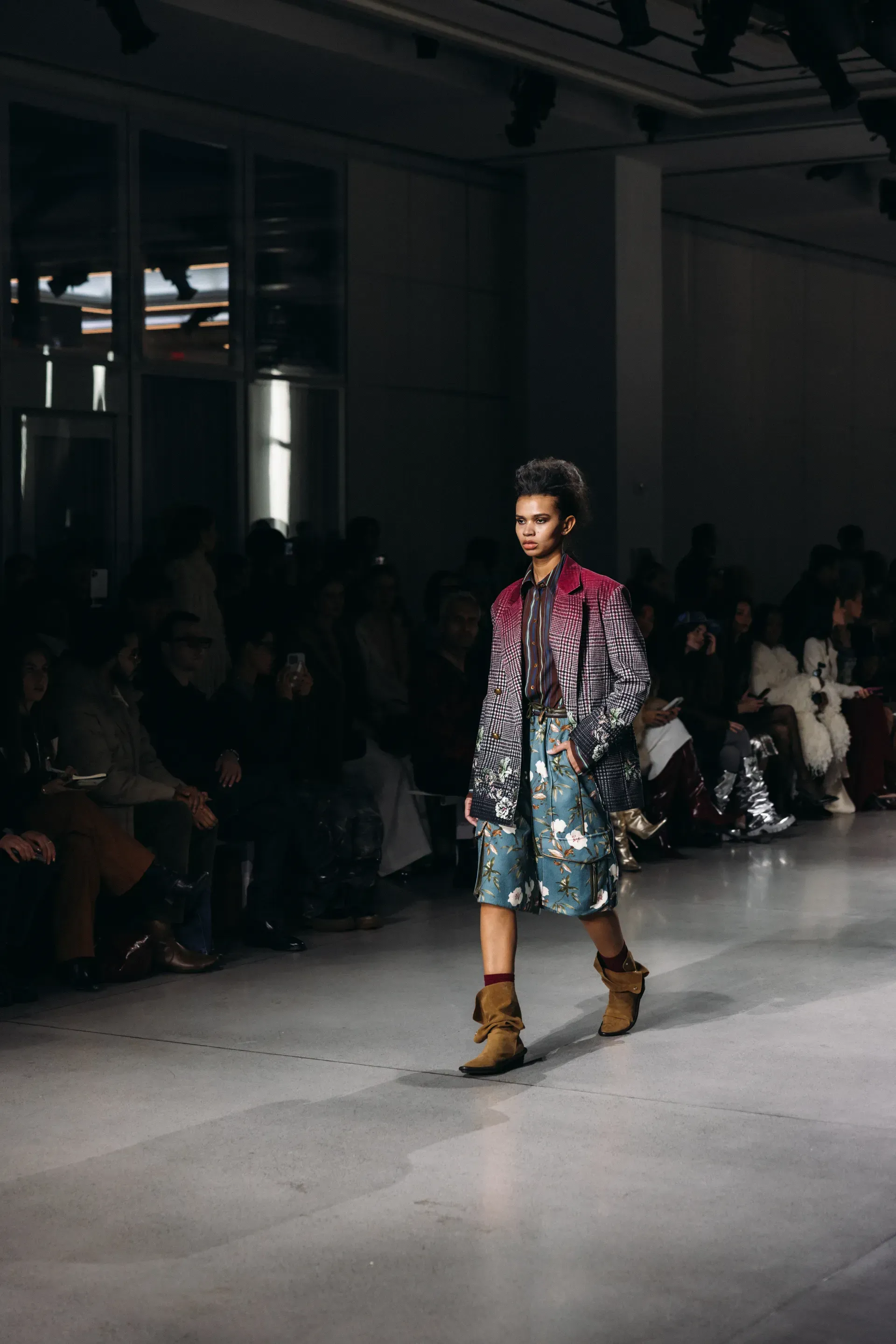 A model is walking down the runway at a fashion show.