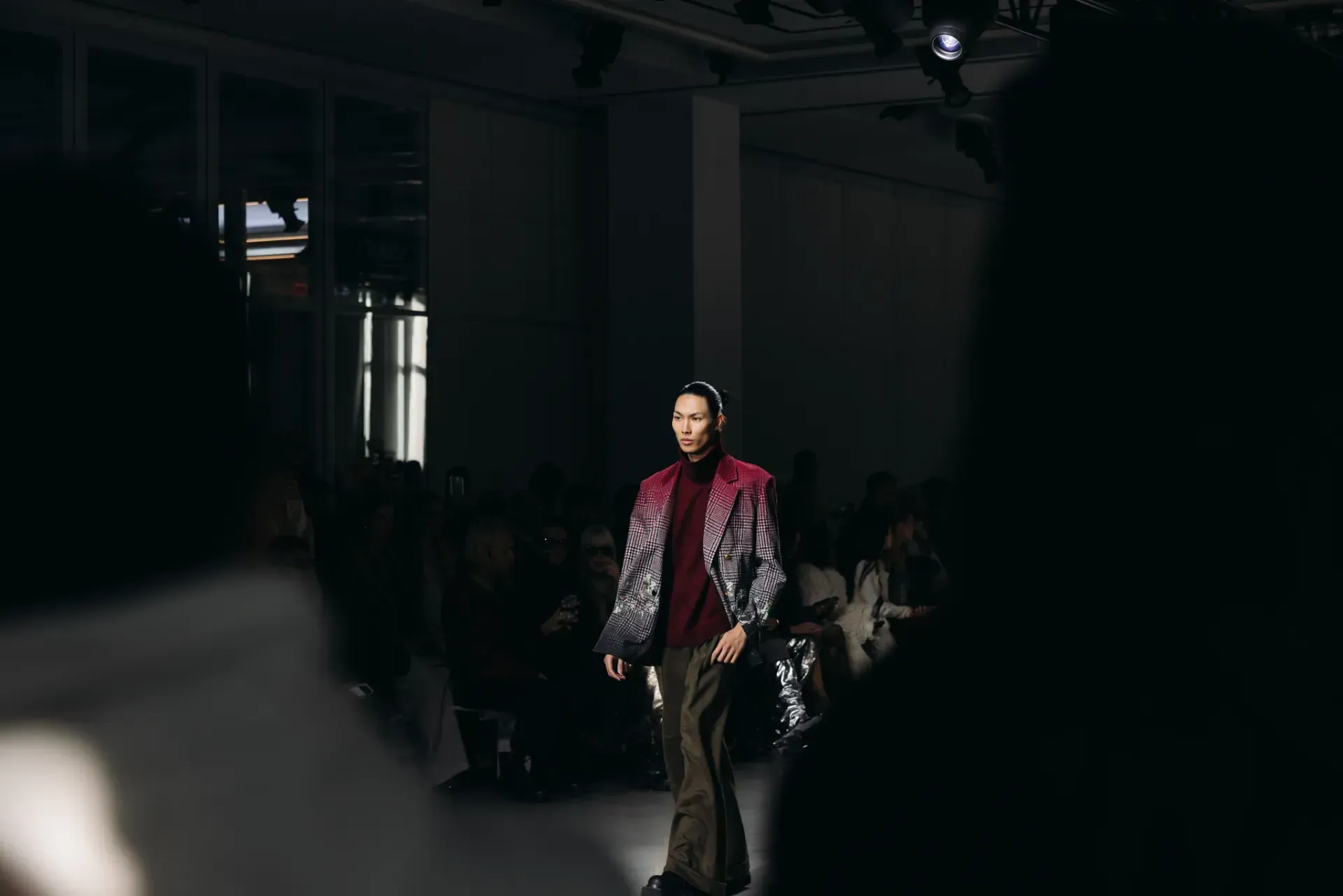 A model is walking down the runway at a fashion show.