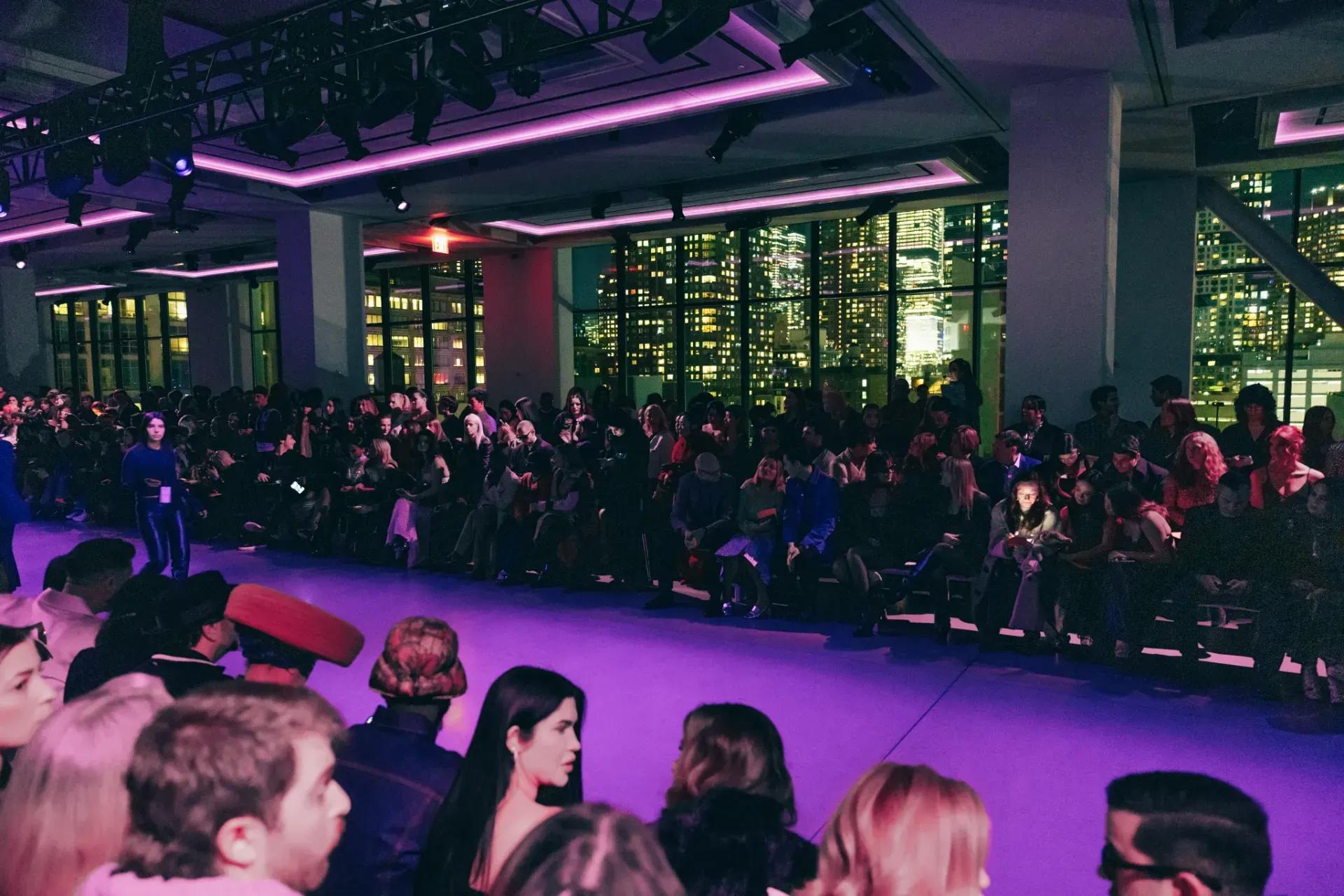 A large crowd of people are watching a fashion show