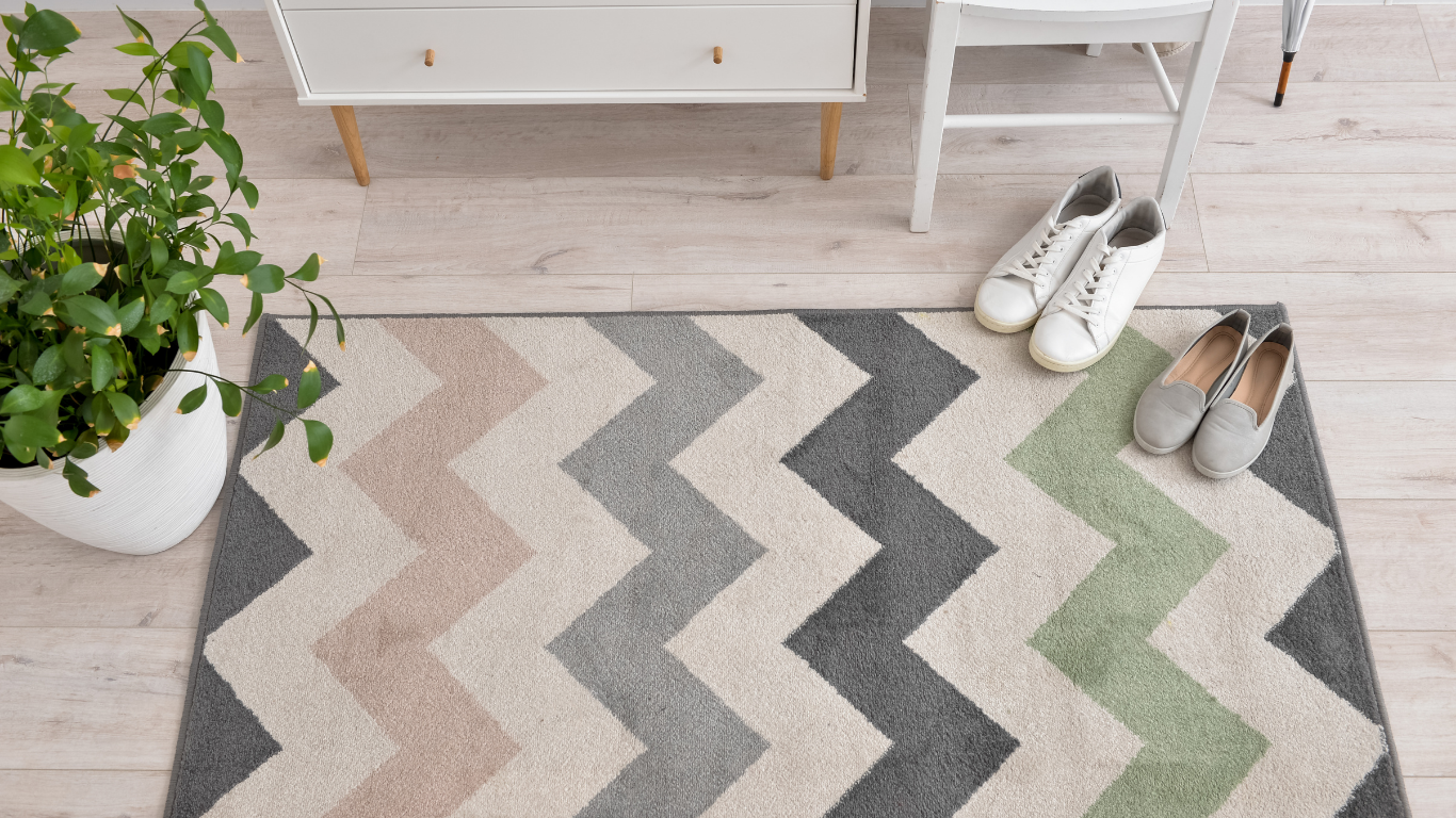 A rug with a chevron pattern and a pair of shoes on it.