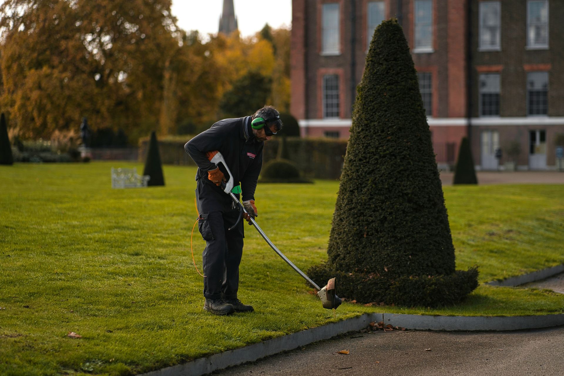 Lawn maintenance Boulder CO cost with a freshly mowed green lawn and professional landscaping crew