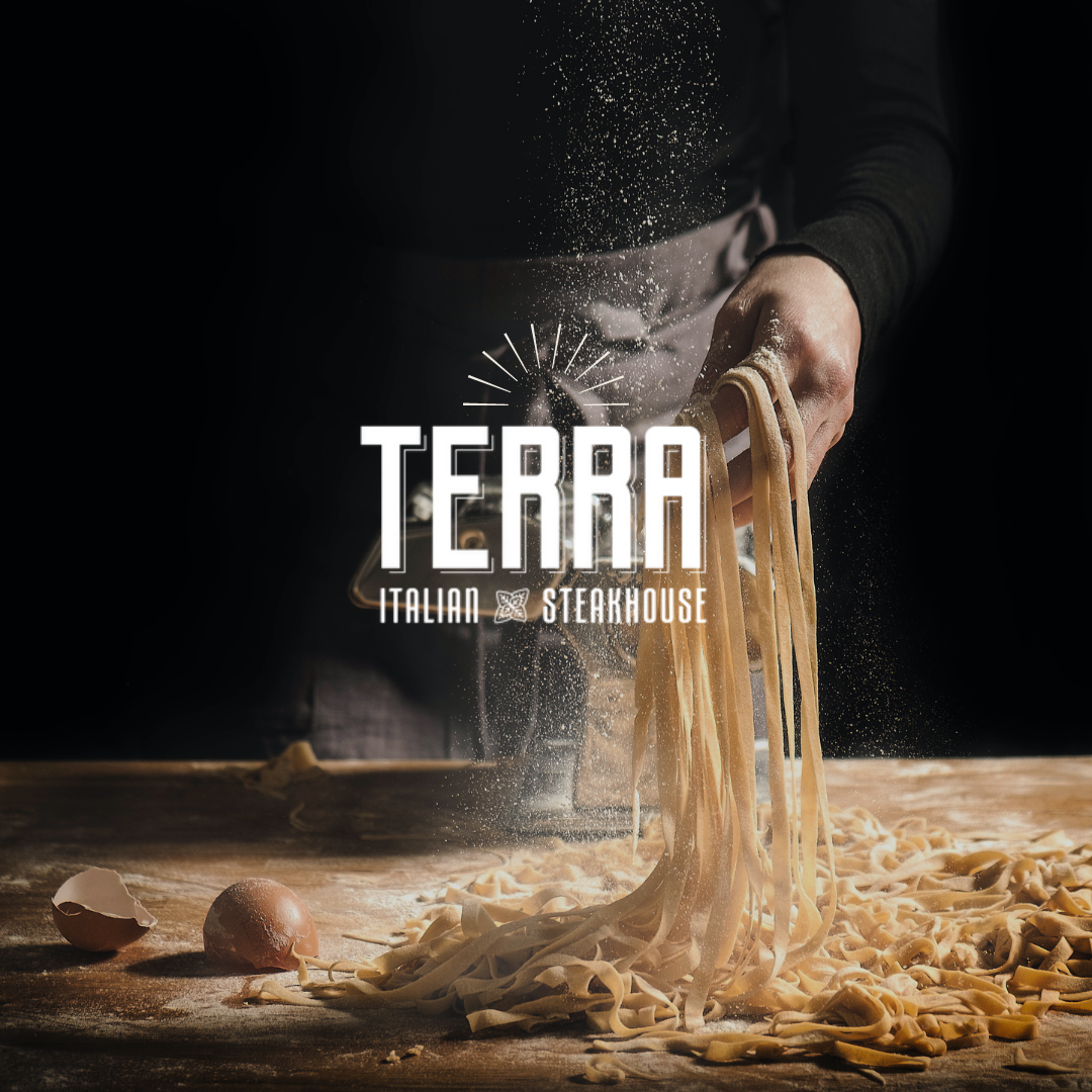 A person is pouring pasta into a bowl on a table.