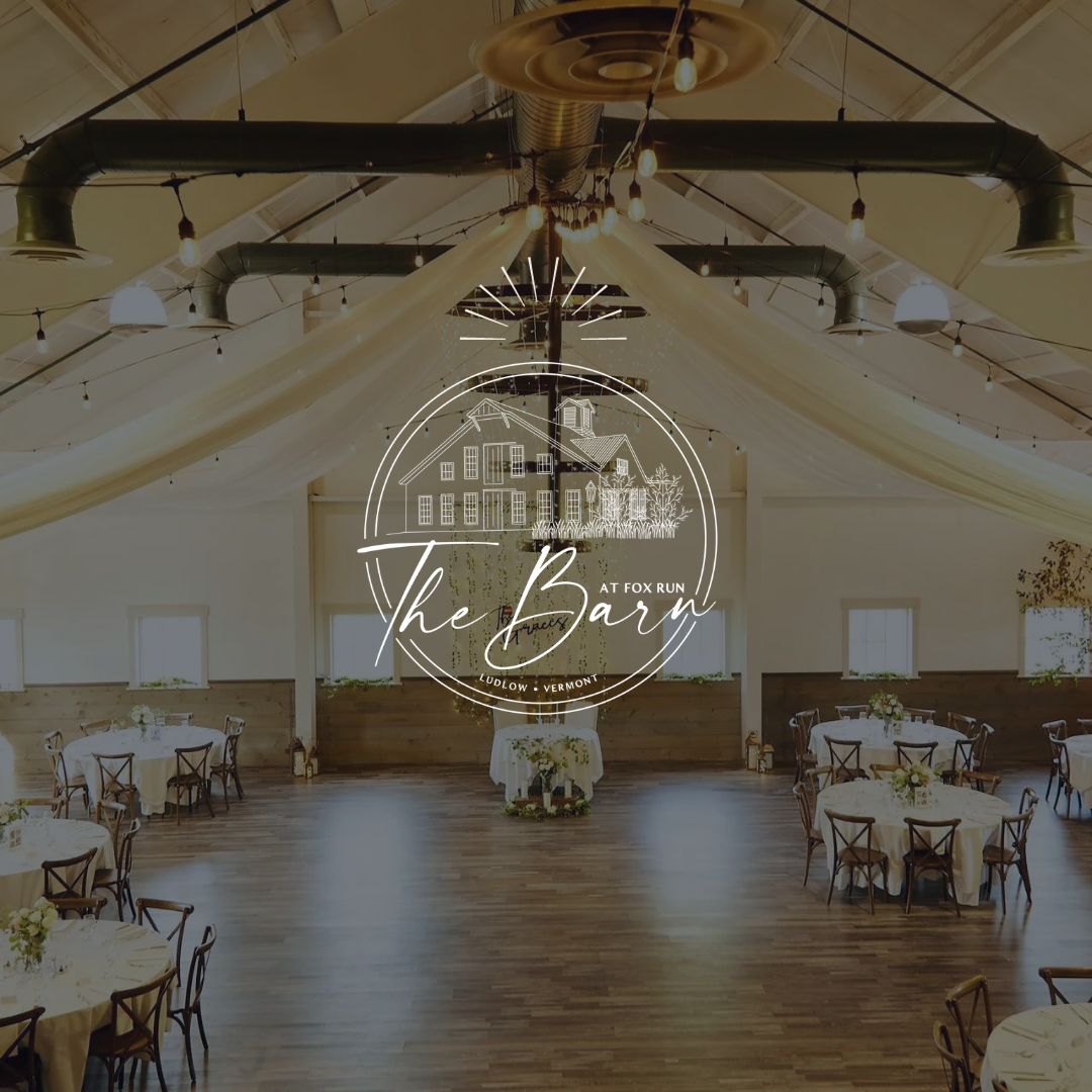 A large room with tables and chairs and a logo for the barn