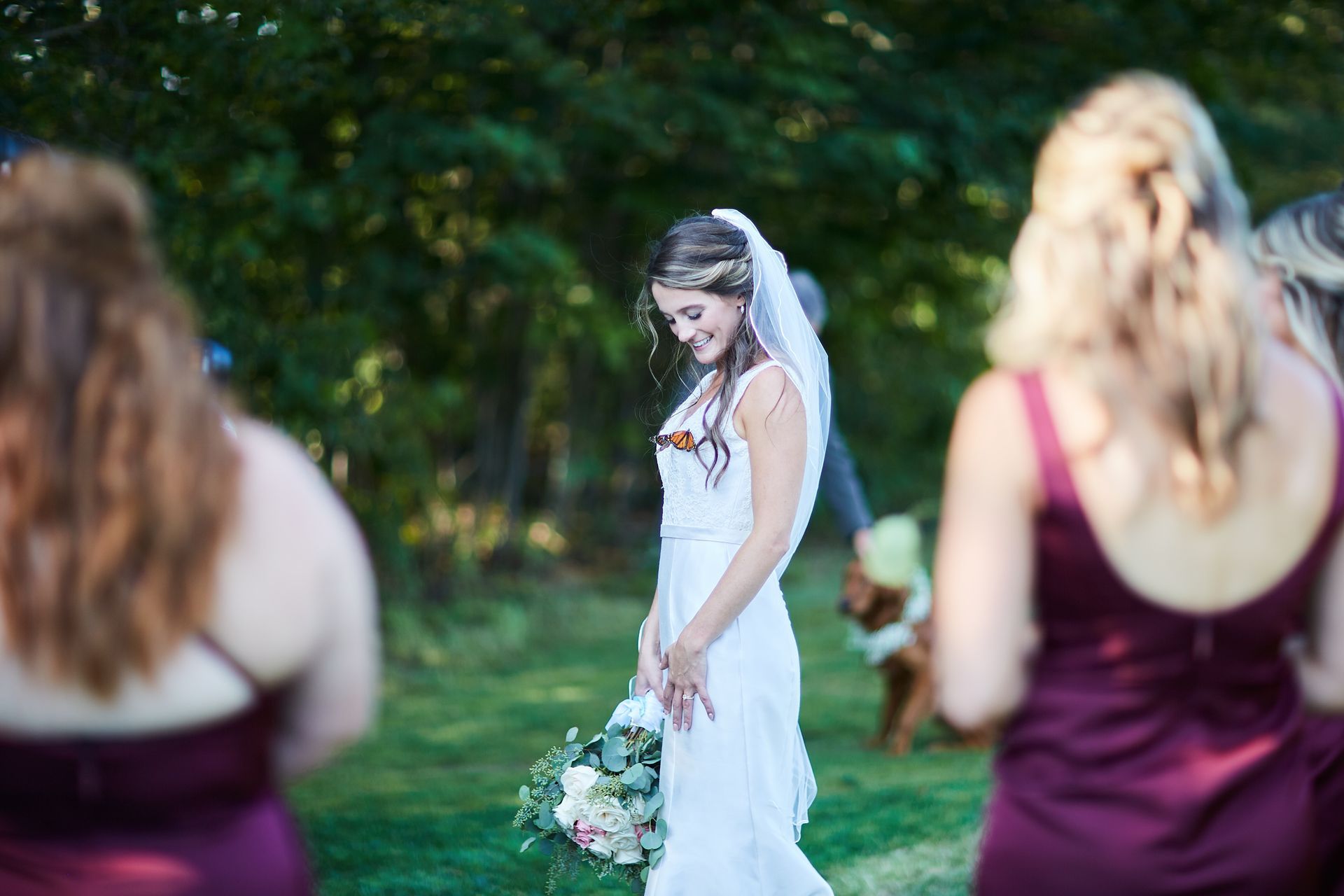 A bride and her bridesmaids are standing in a field.