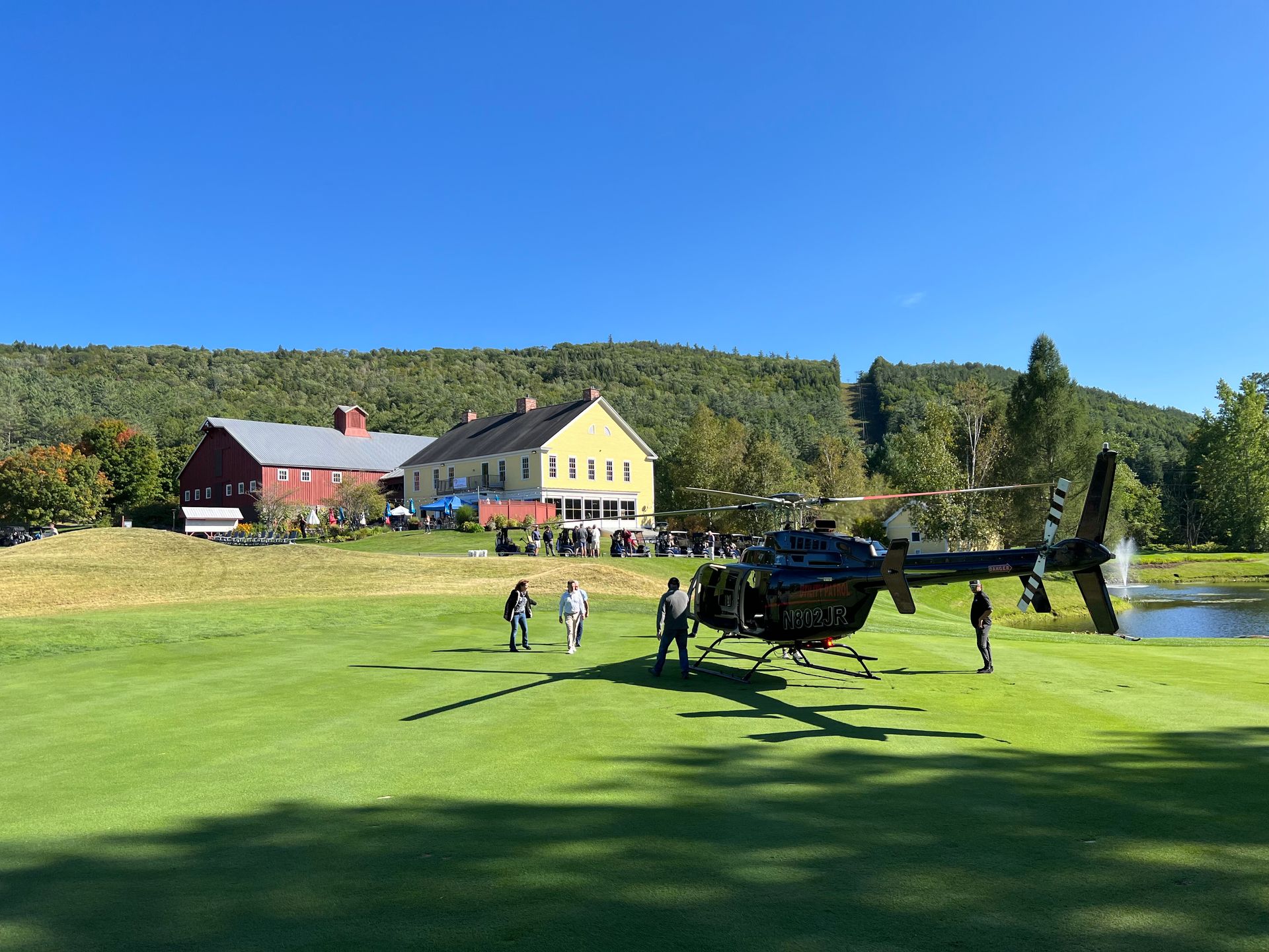 A helicopter is sitting on top of a lush green field.