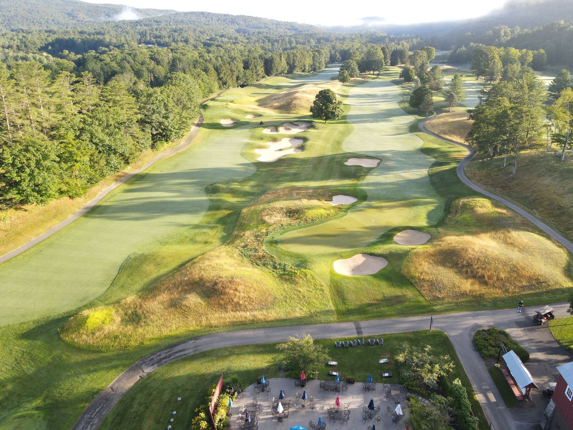 An aerial view of a golf course surrounded by trees.