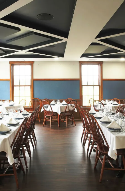 A dining room with tables and chairs set for a party