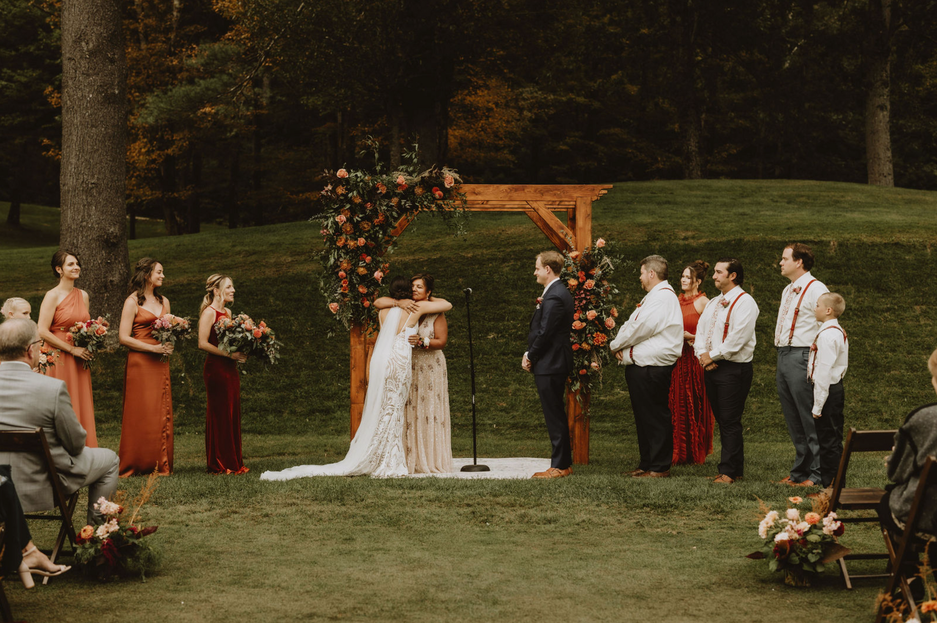 A bride and groom are hugging each other during their wedding ceremony.