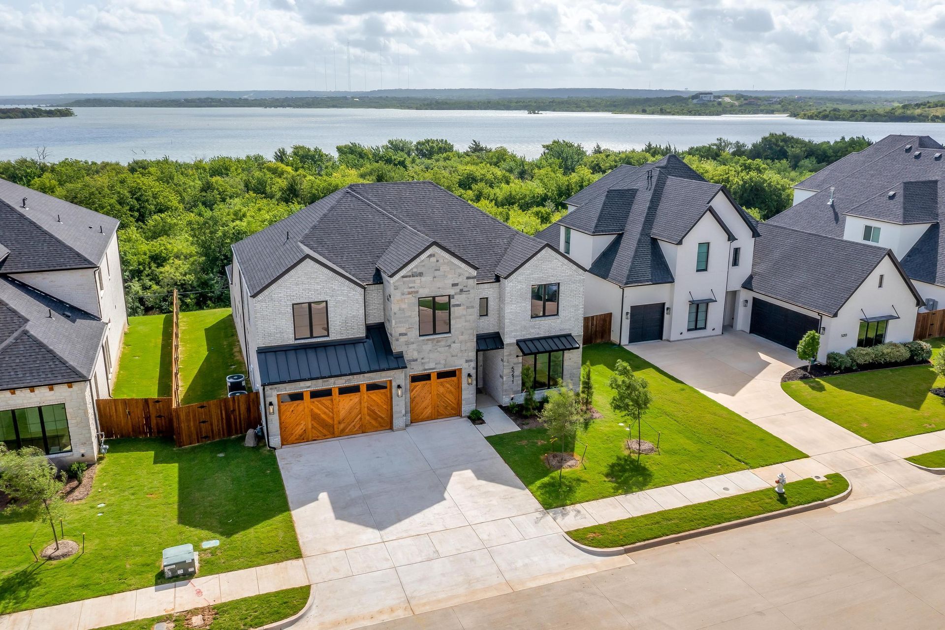 An aerial view of a residential neighborhood with a lake in the background.