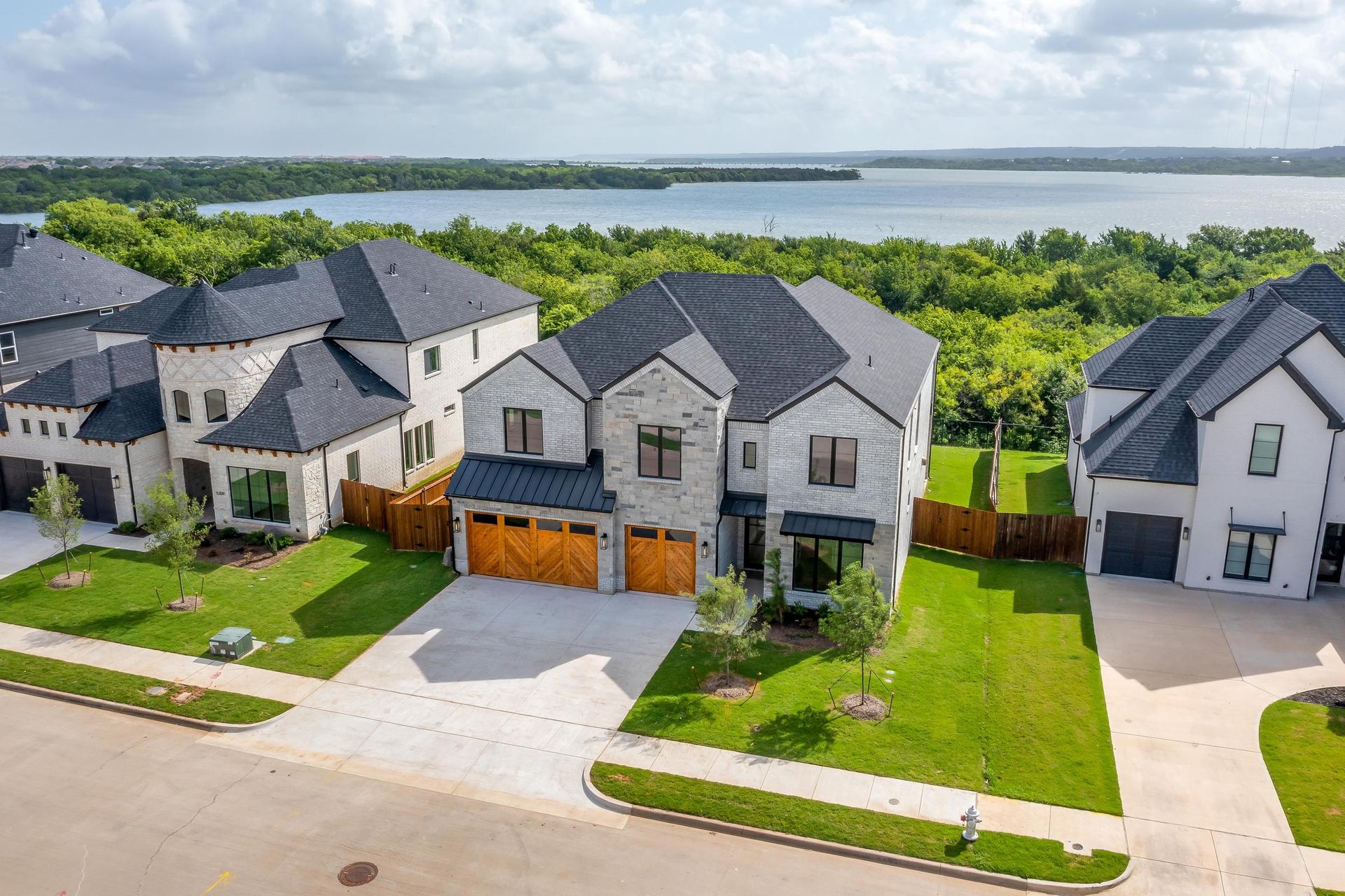 An aerial view of a residential neighborhood with a lake in the background.