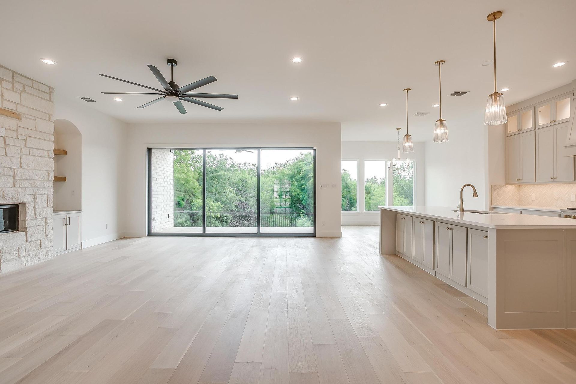 There is a ceiling fan in the living room and a sliding glass door in the kitchen.