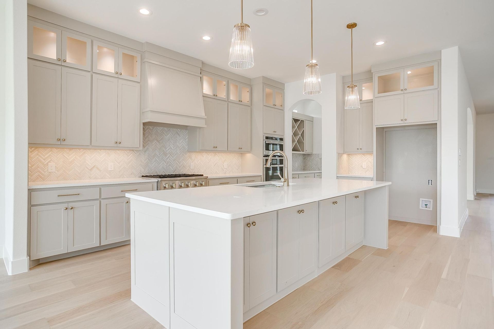 A kitchen with white cabinets and a large island in the middle.