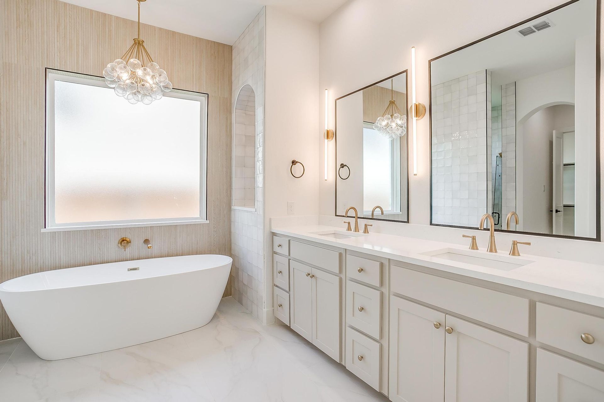 A bathroom with a bathtub , sinks , mirrors and a window.