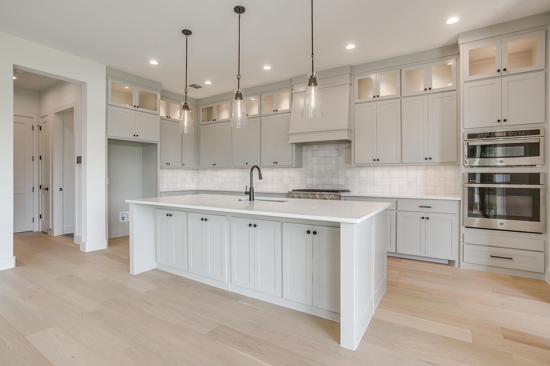 A large kitchen with white cabinets and a large island.