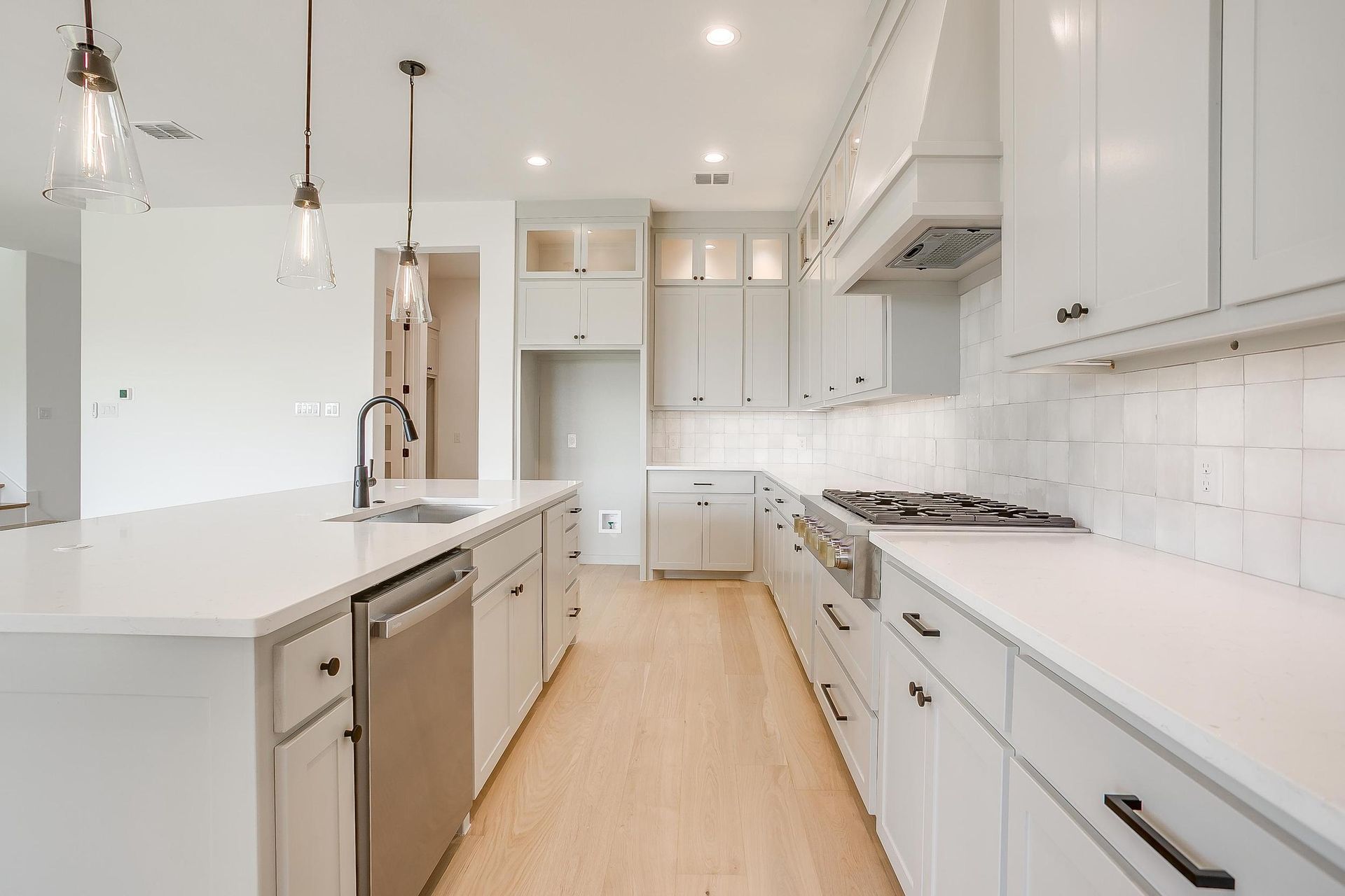 A kitchen with white cabinets and stainless steel appliances.