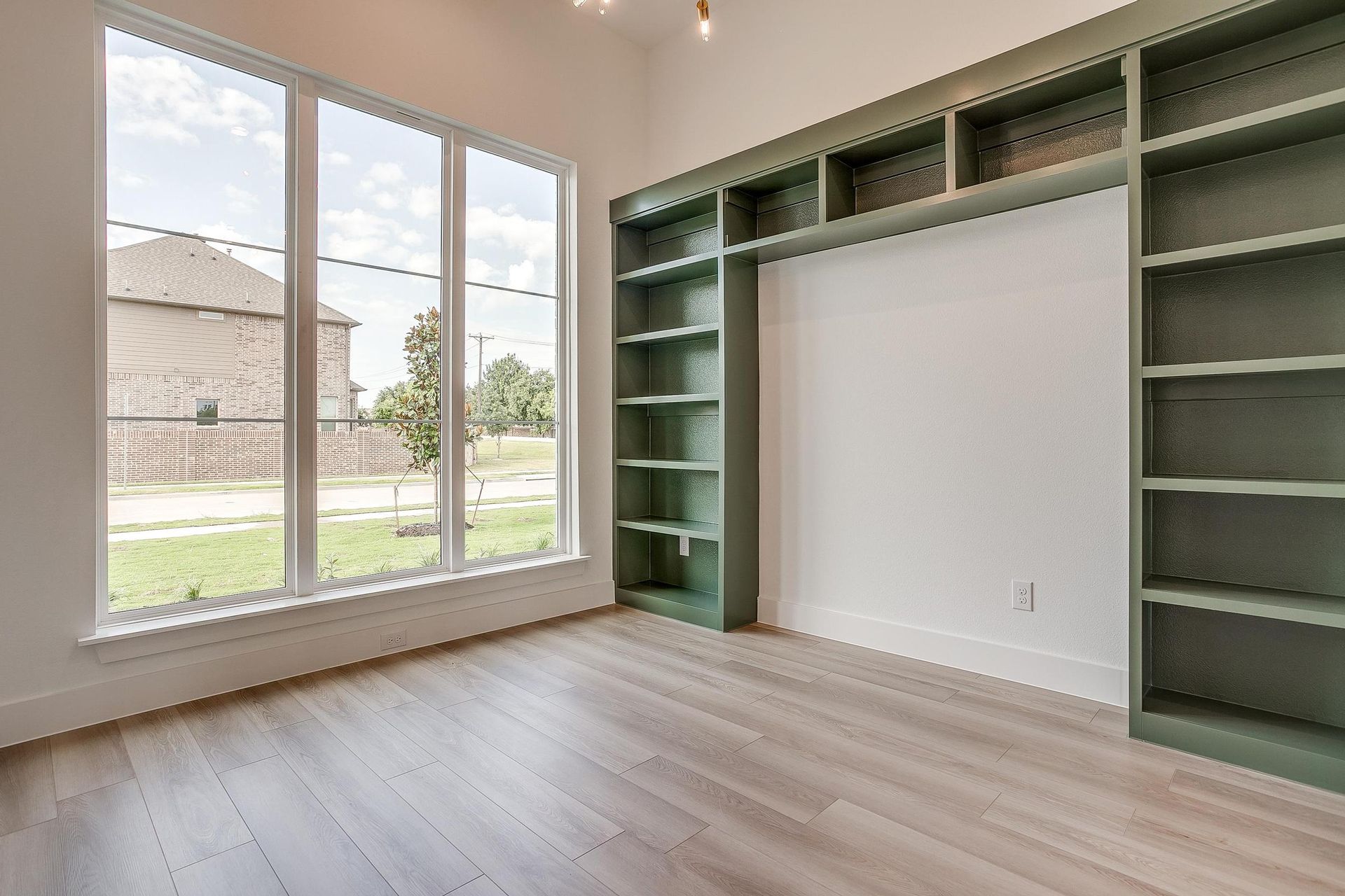 An empty room with a lot of shelves and windows.