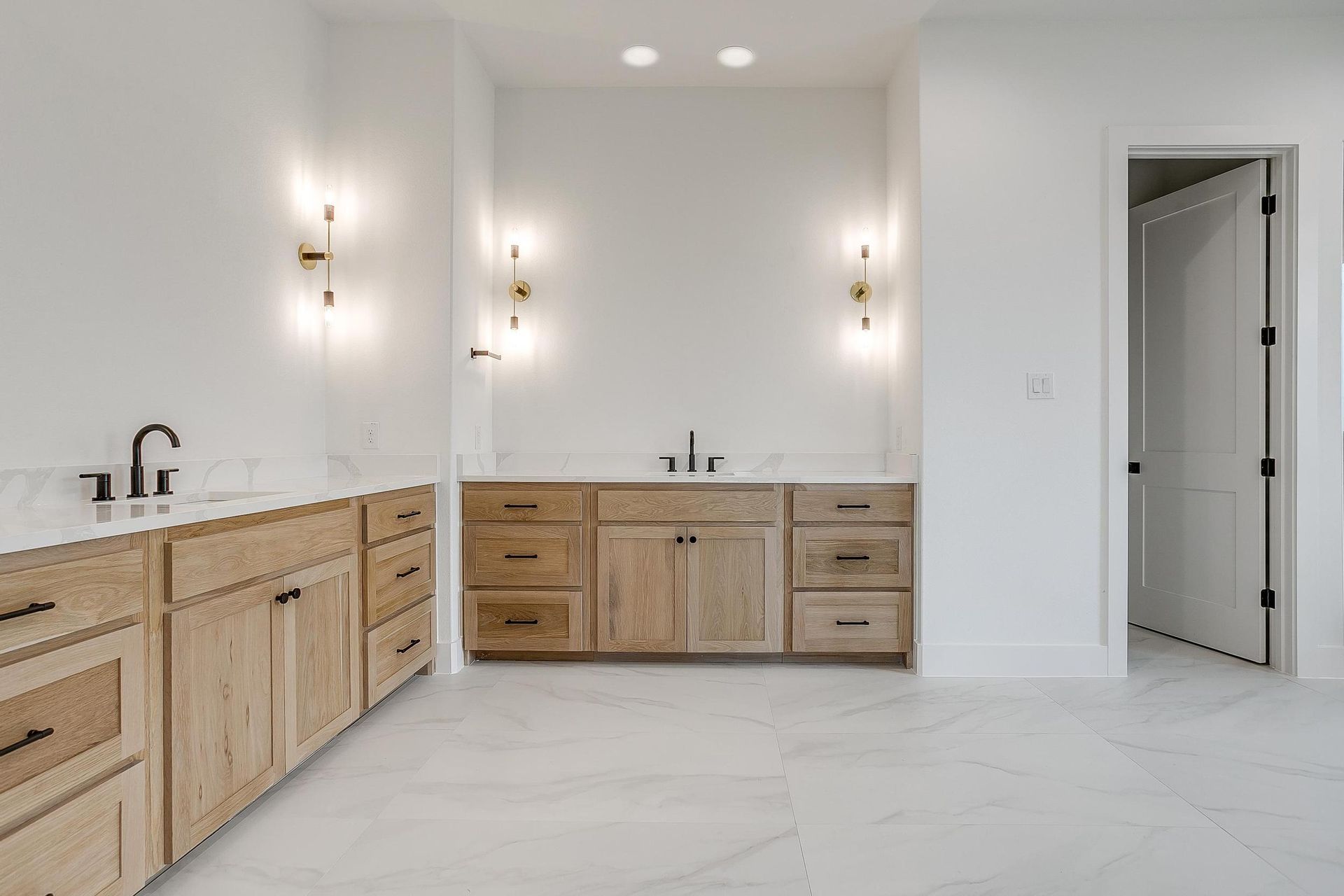 A bathroom with wooden cabinets and marble counter tops.
