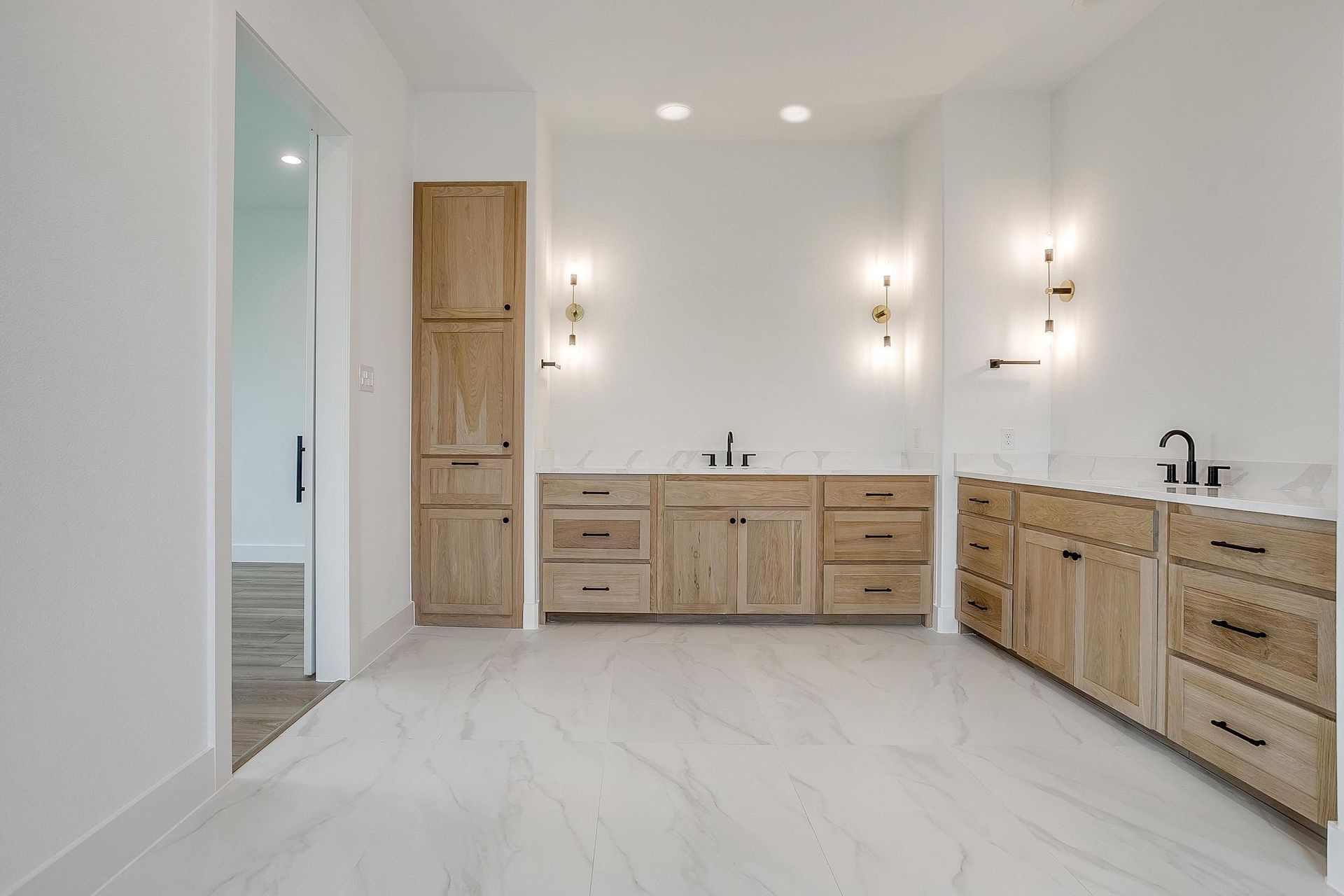 A large empty room with wooden cabinets and a sink.