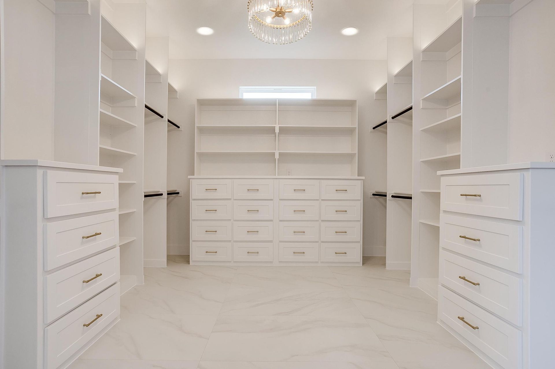 A large walk in closet with lots of shelves and drawers.