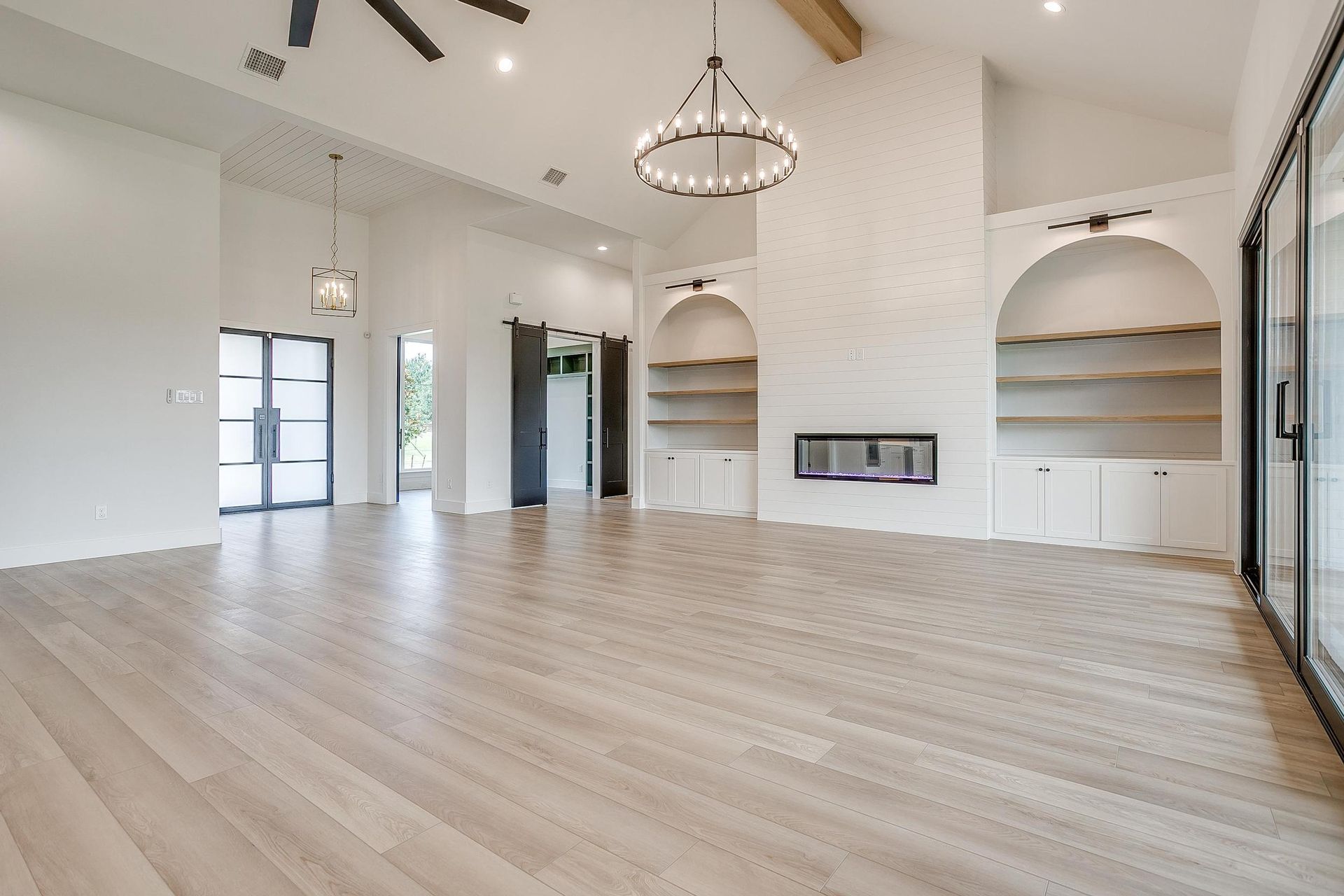 An empty living room with hardwood floors and a fireplace.