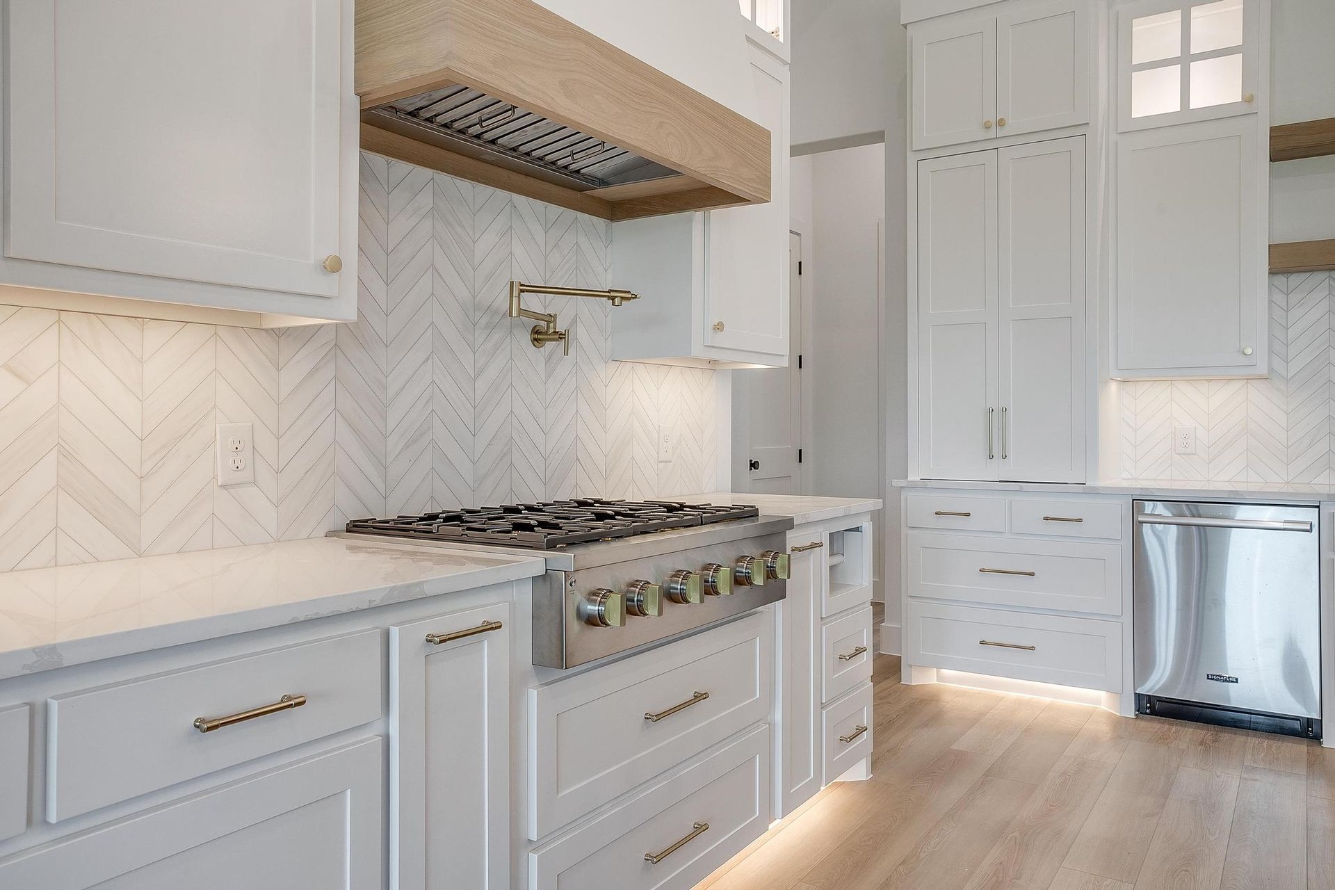 A kitchen with white cabinets and stainless steel appliances.