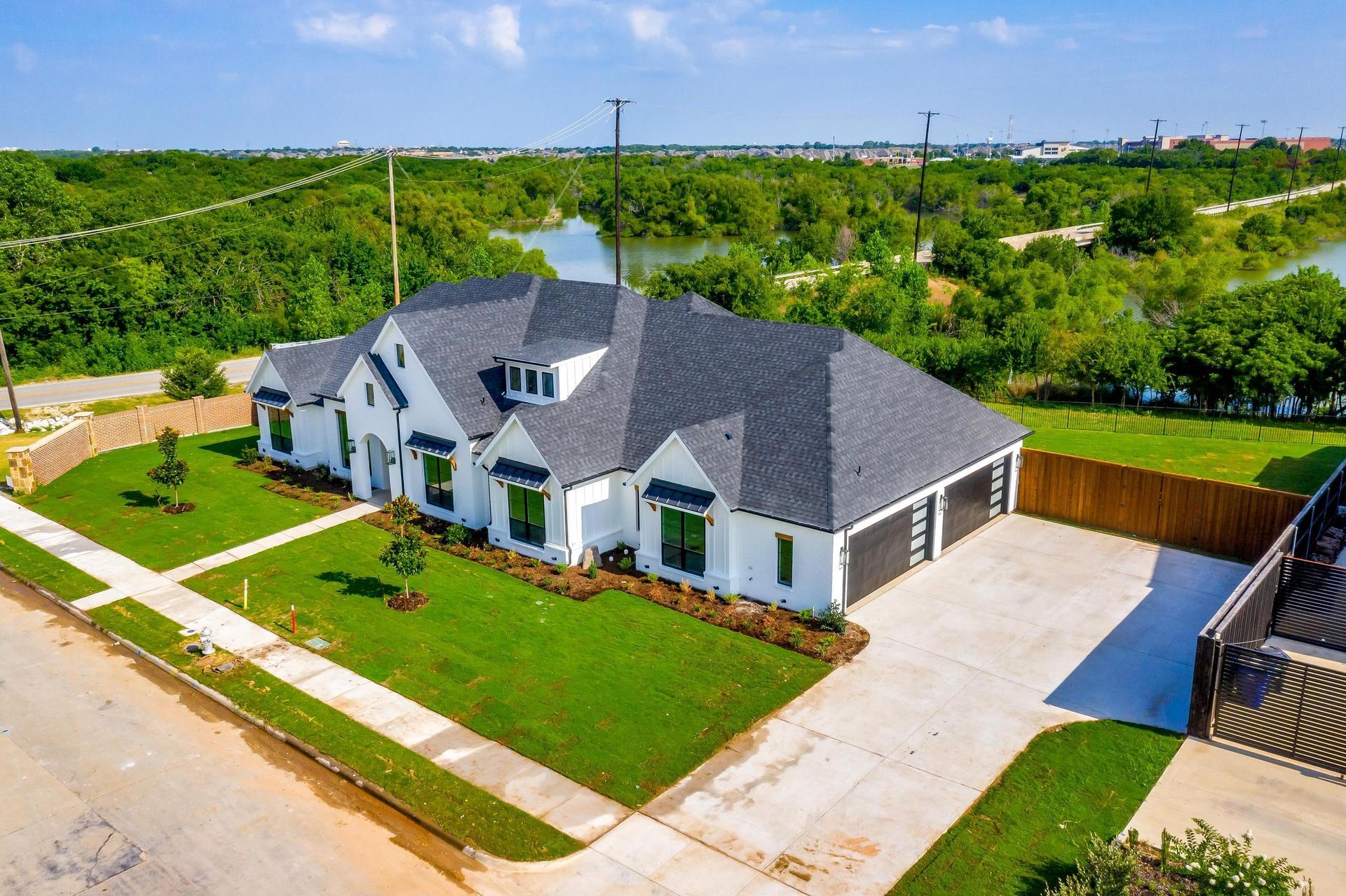 An aerial view of a large white house with a gray roof