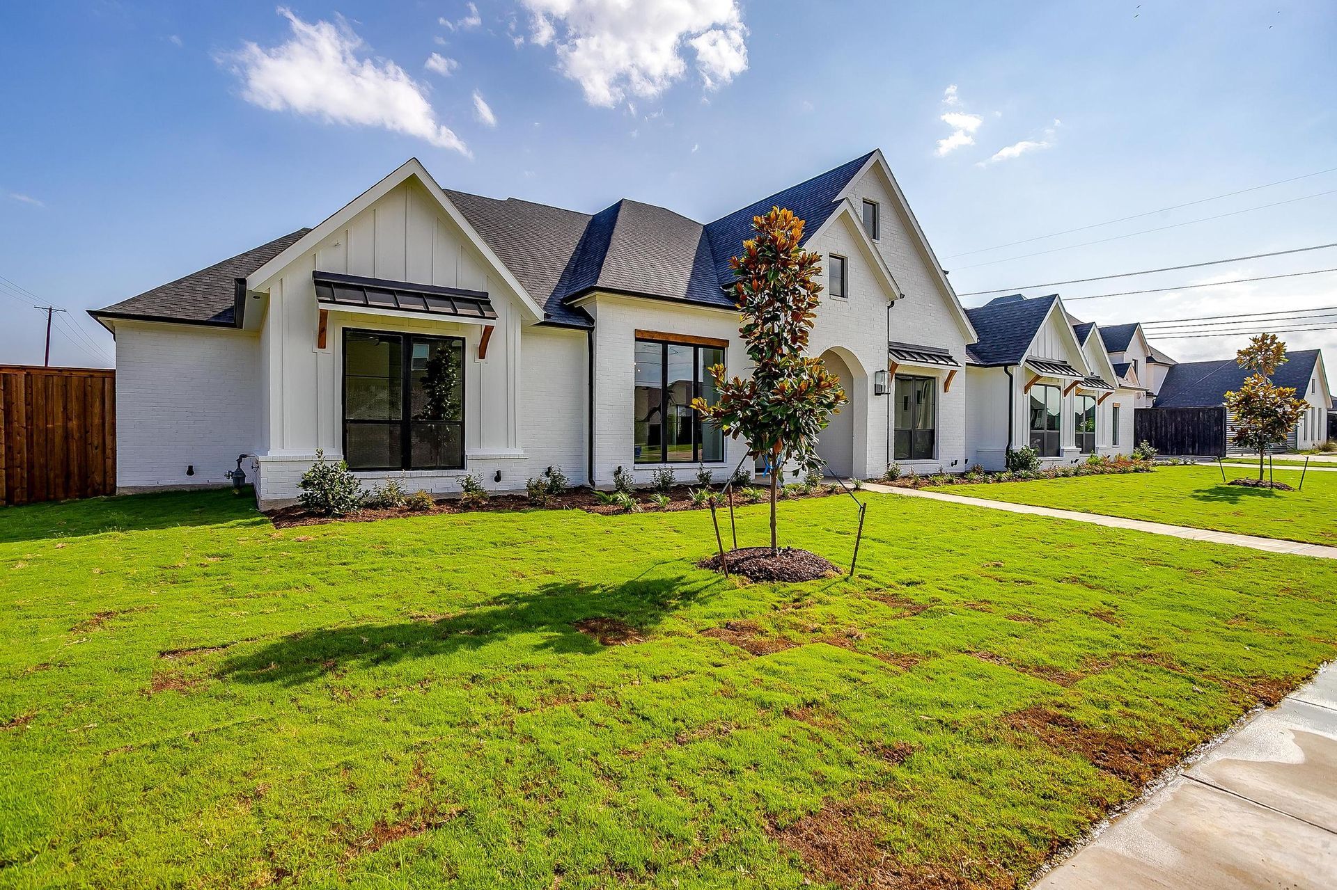 A large white house with a lush green lawn in front of it.