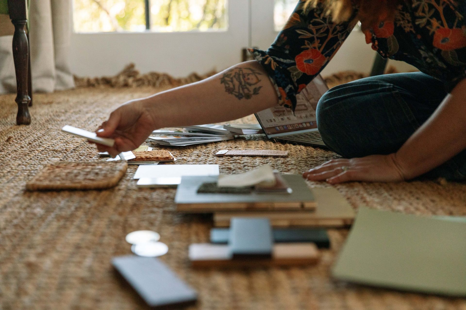 Person Arranging Wooden Samples And Cards On A Woven Rug — Everyday Interiors in Helensburgh, NSW