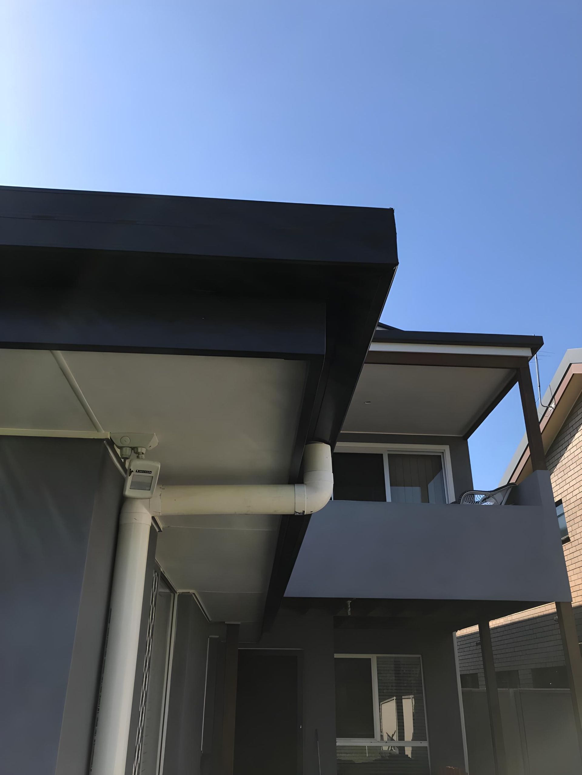 A House With A Gutter On The Side Of It And A Blue Sky In The Background — Premier Roofing Solutions In Lennox Head, NSW