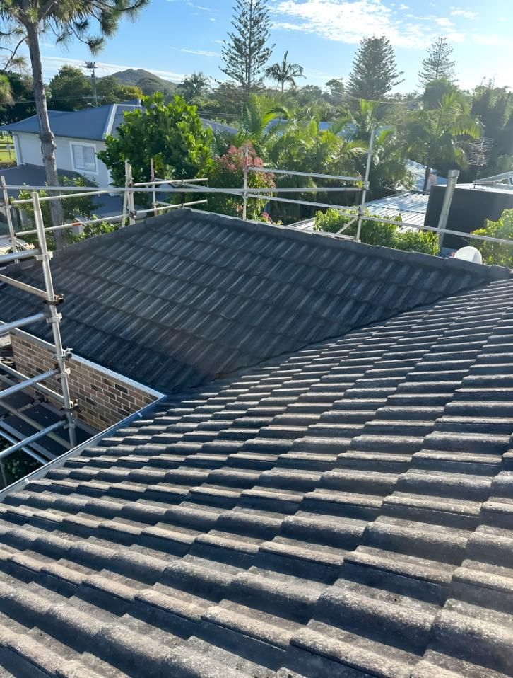 A Close Up Of A Tiled Roof With Scaffolding On It — Premier Roofing Solutions In Tweed Heads, NSW