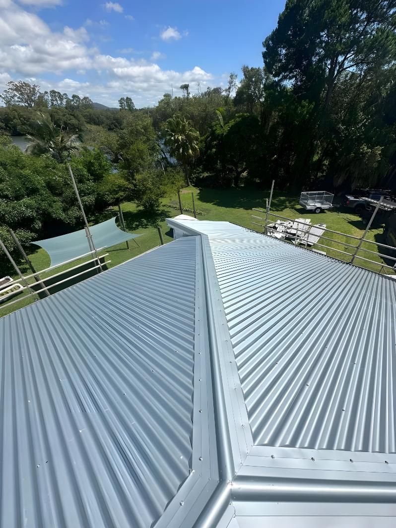 A Close Up Of A Metal Roof With Trees In The Background — Premier Roofing Solutions In Kyogle, NSW