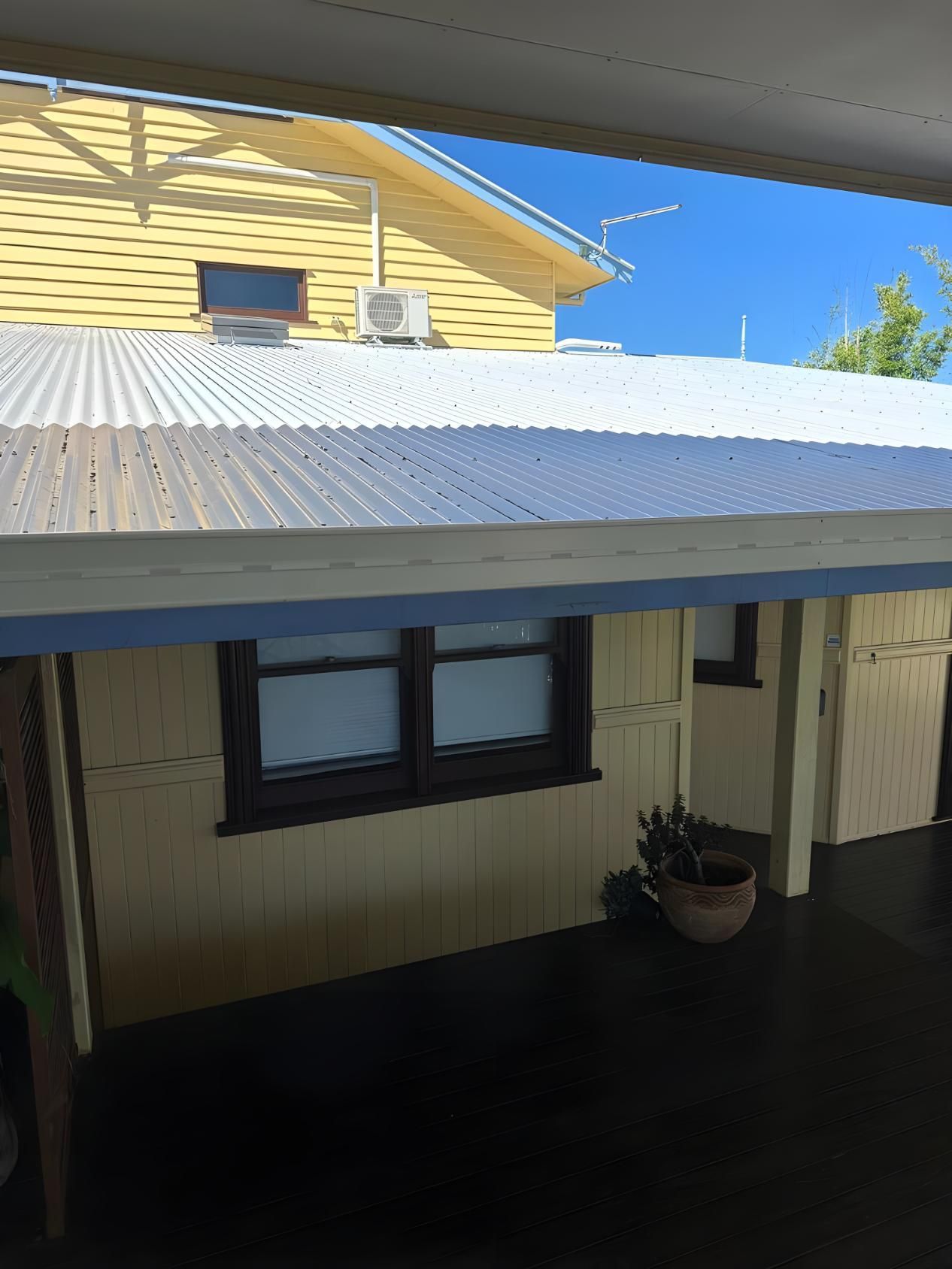 A Yellow House With A White Roof And Two Windows — Premier Roofing Solutions In Lennox Head, NSW