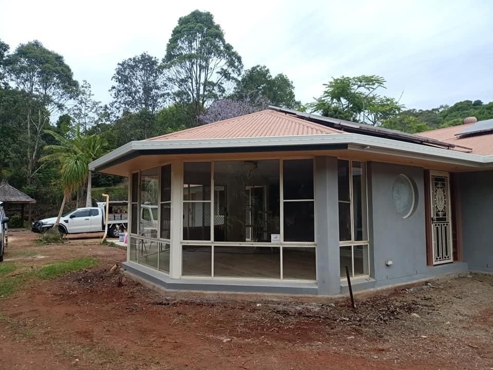 A Large House With A Lot Of Windows Is Sitting In The Middle Of A Dirt Field — Premier Roofing Solutions In Lennox Head, NSW