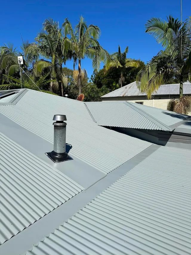 A Roof With A Chimney On It And Palm Trees In The Background — Premier Roofing Solutions In Lennox Head, NSW