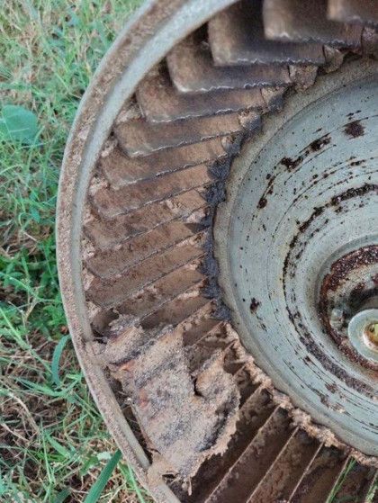 A Close Up of a Rusty Fan Sitting in the Grass