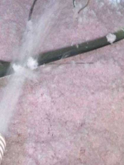 A Hose is Being Used to Blow Insulation Into a Room