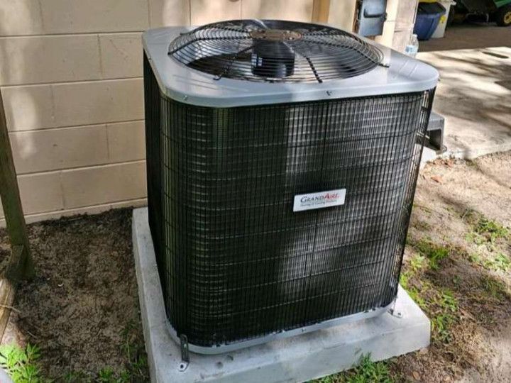 A Black Air Conditioner is Sitting on Top of a Concrete Block