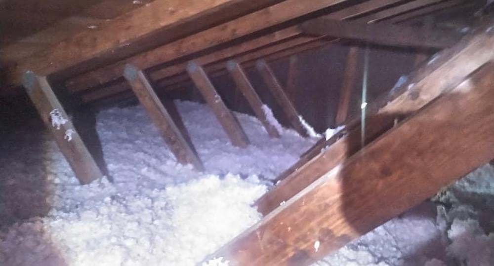 There is a lot of insulation in the attic of a house.